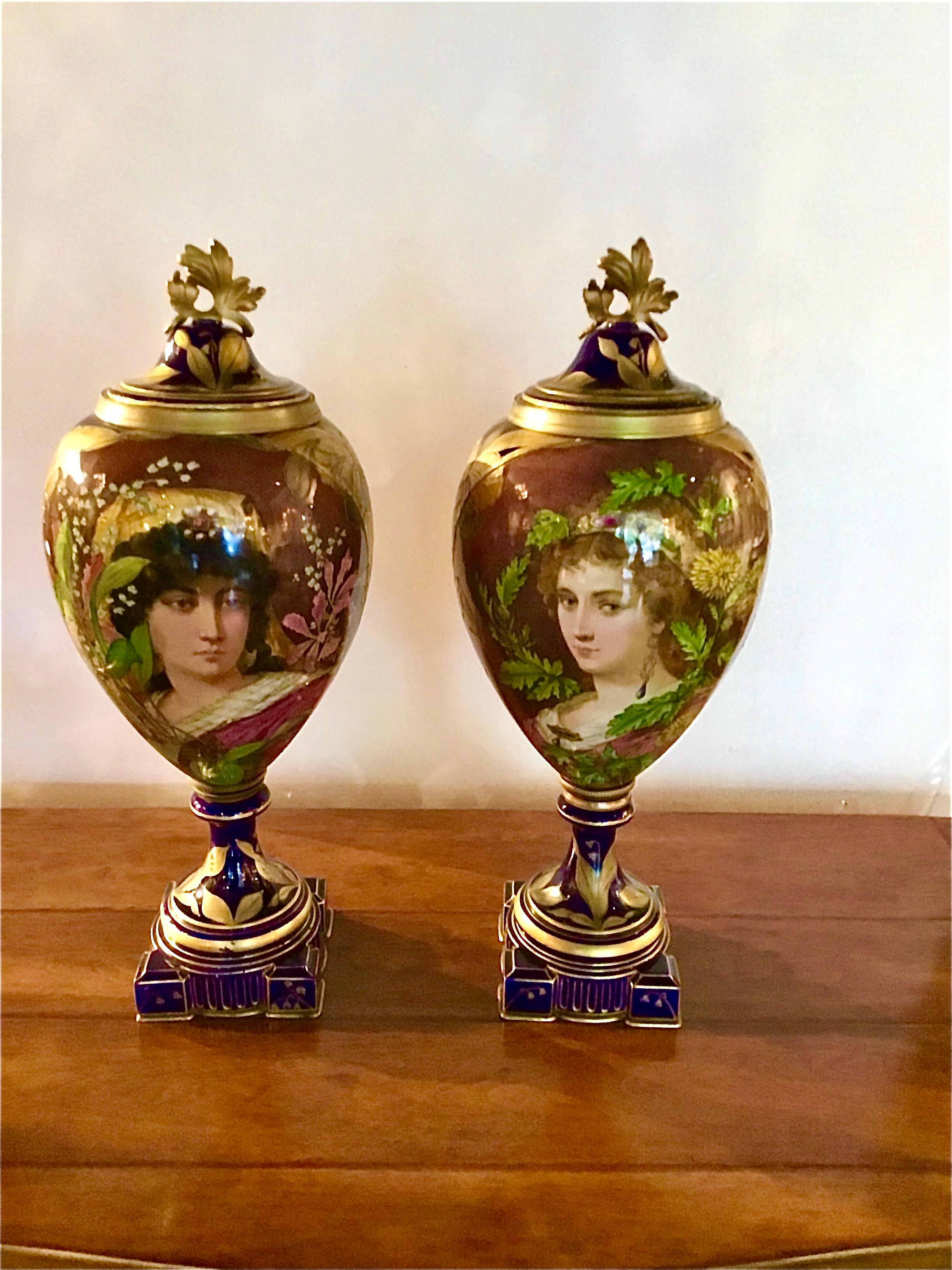 Exceptional pair of portrait vases of two beautiful women; one has blonde 
Hair and the other dark hair. They are set on a dark blue cobalt background 
With gilt floral and foliate designs at the base, sides and the reverse
Sides. The paintings