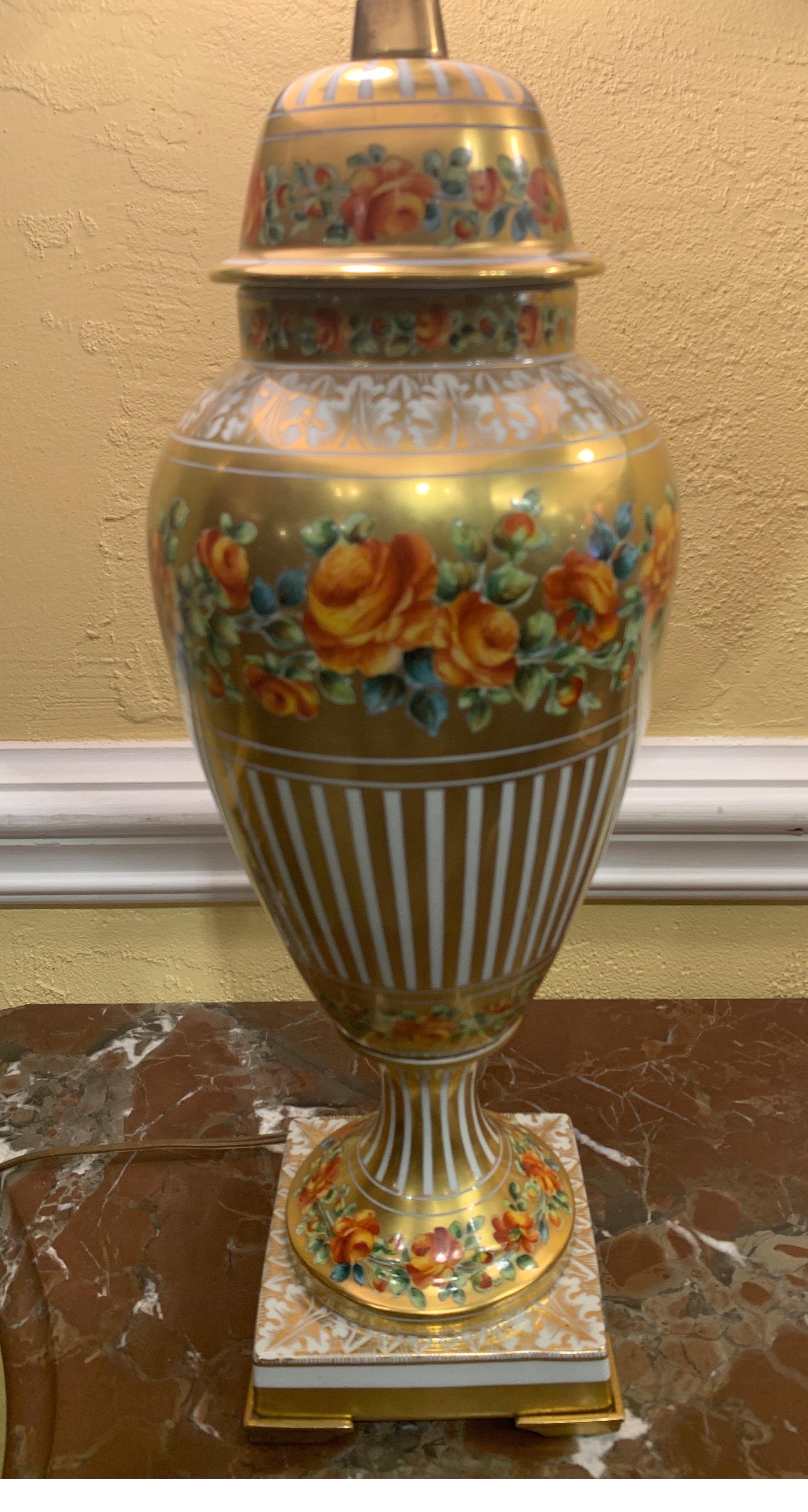 Pair of French porcelain urns converted into lamps by Marbro of California. Floral decorated scenes. Bases are accented with bronze feet.