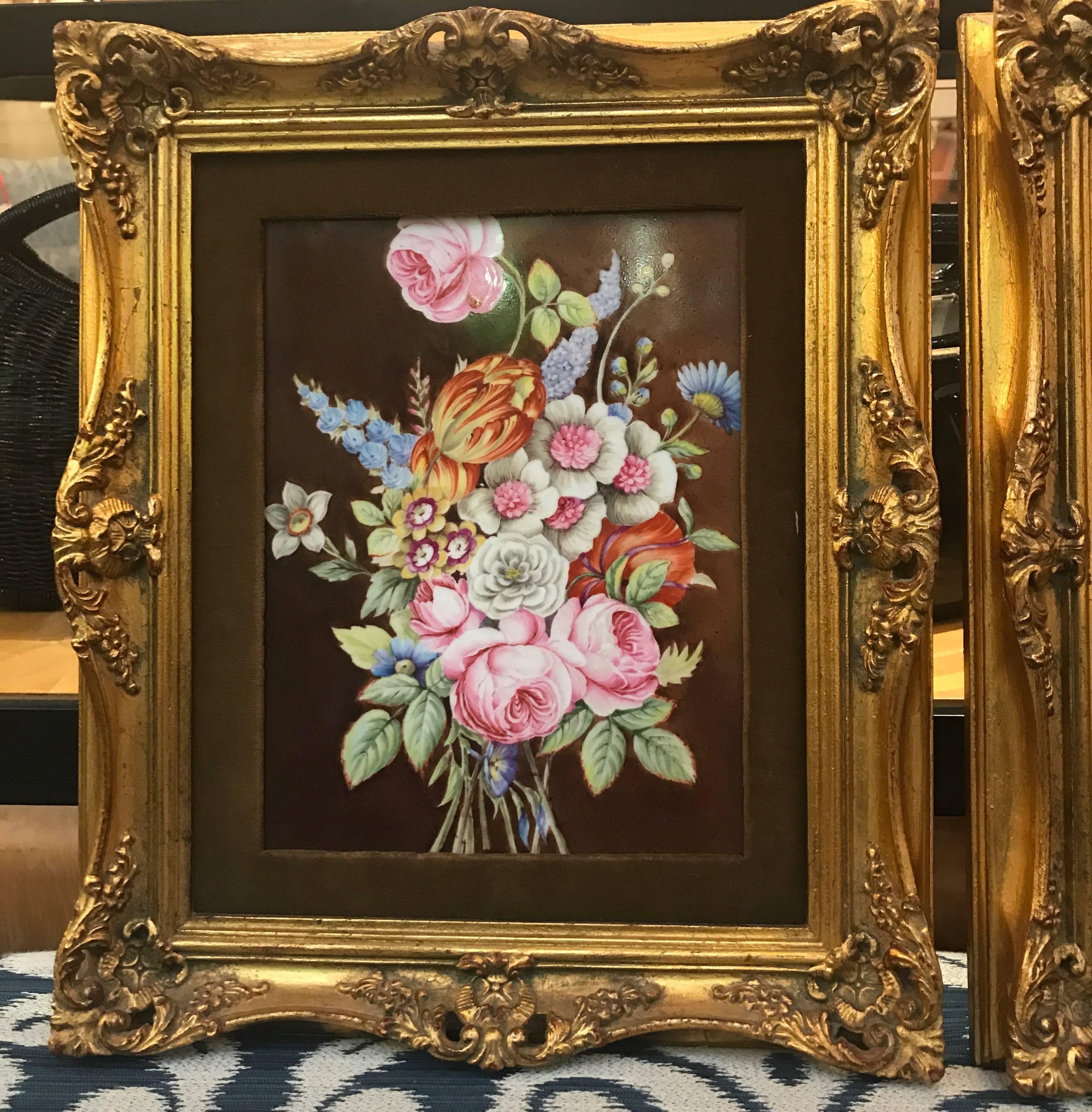 A pair of hand-painted porcelain floral plaques. The porcelain is circa 1880 and the gilt carved wood frames were custom-made for them, circa 1950. The plaques alone measure 8