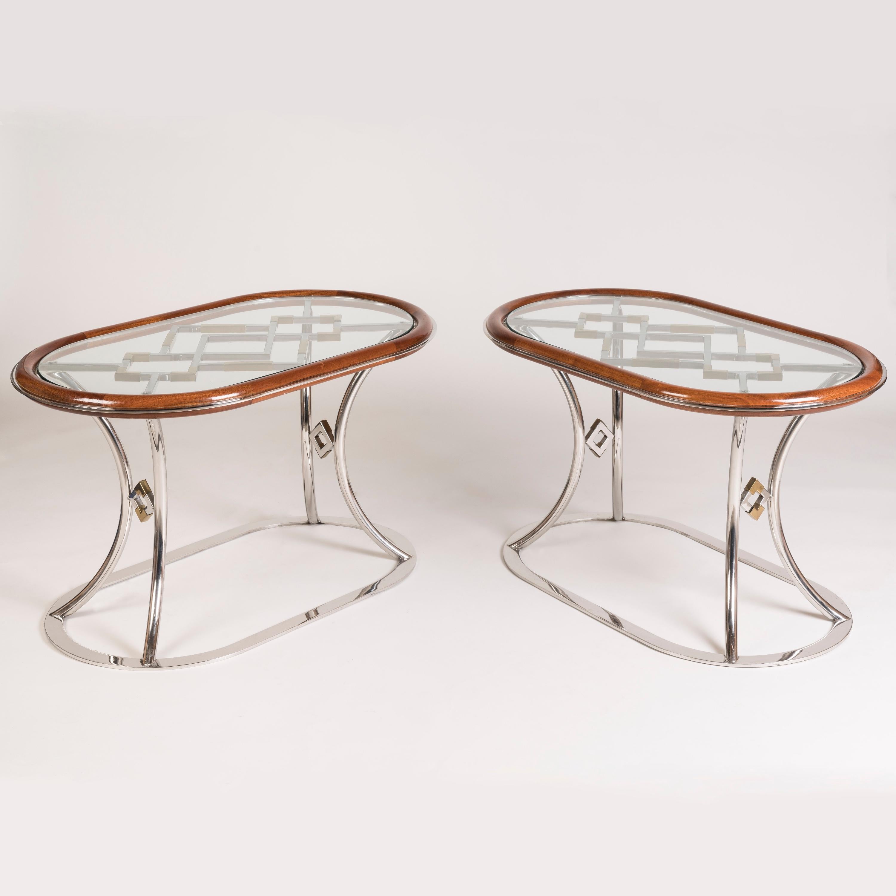 Ein Paar französische Nachkriegs-Couchtische aus Chrom und Messing
Zuschreibung an Maison Jansen

Jeder Tisch hat eine ovale Glasplatte und einen Mahagonirand. Er steht auf einem verchromten Sockel mit geschwungenen Beinen und offenem Spalierdesign