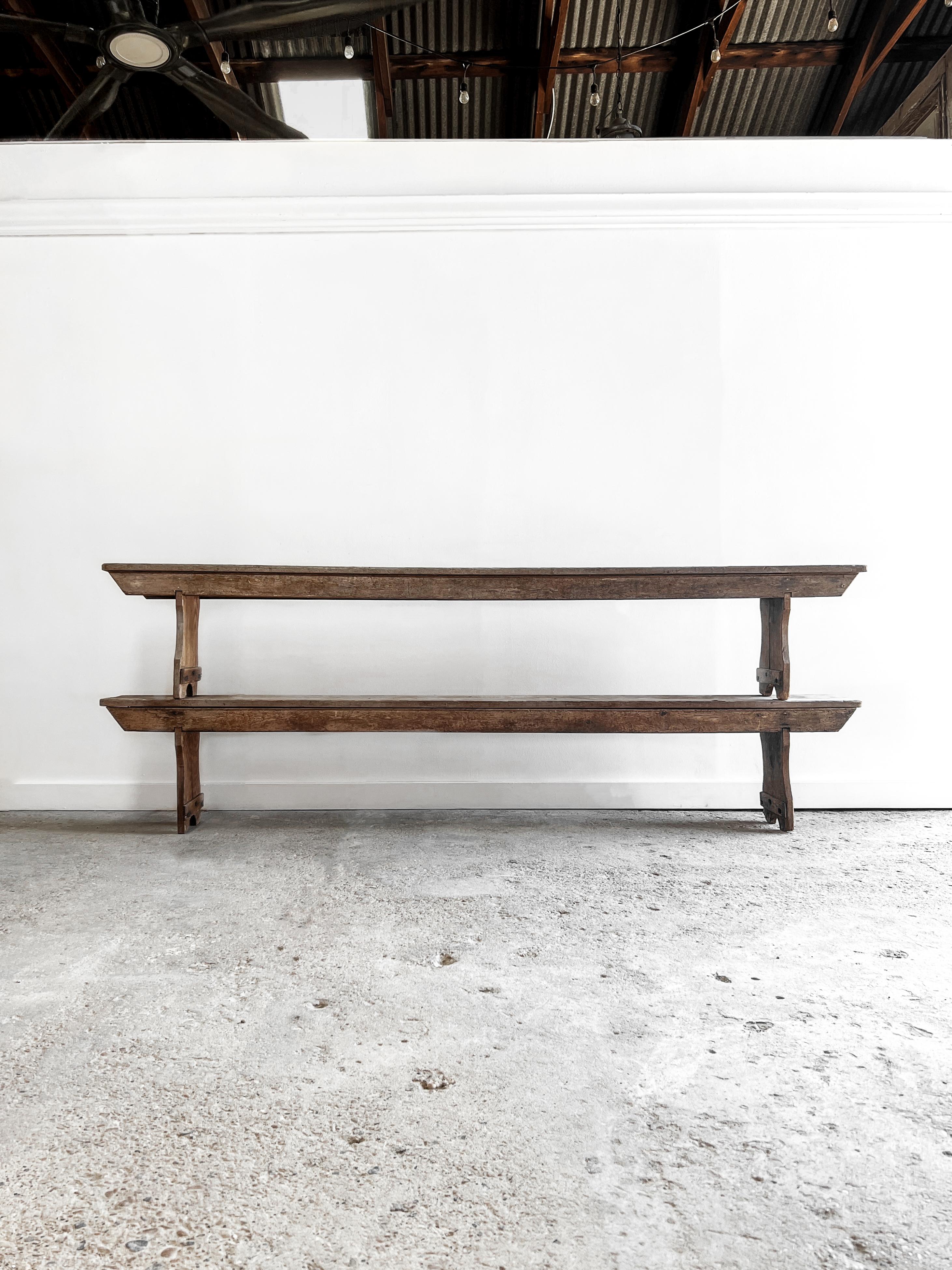 A pair of late 19th-century classic farmhouse benches with a primitive design. Found in France, the benches are crafted from solid pine with a beautiful weathered patina. Sturdy and stylish, the benches will add warmth and vintage charm to your