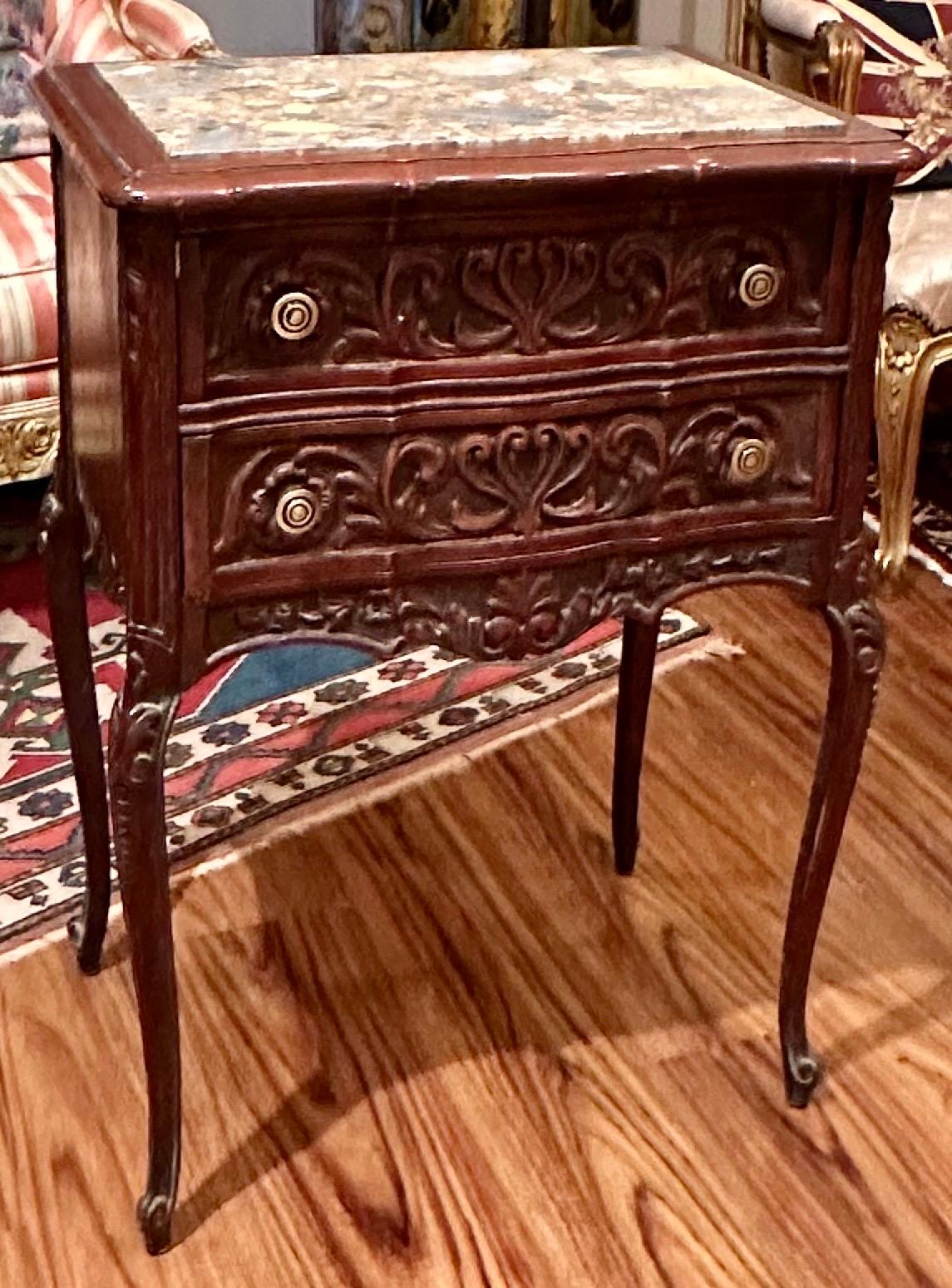 Pair of French Provincial Antique Marble Top Walnut Commodes

Late 19th century antique pair of Louis XV style marble top commodes .Each of the walnut stands have two heavily carved drawers with stylized foliate and scrollwork intertwined. Period