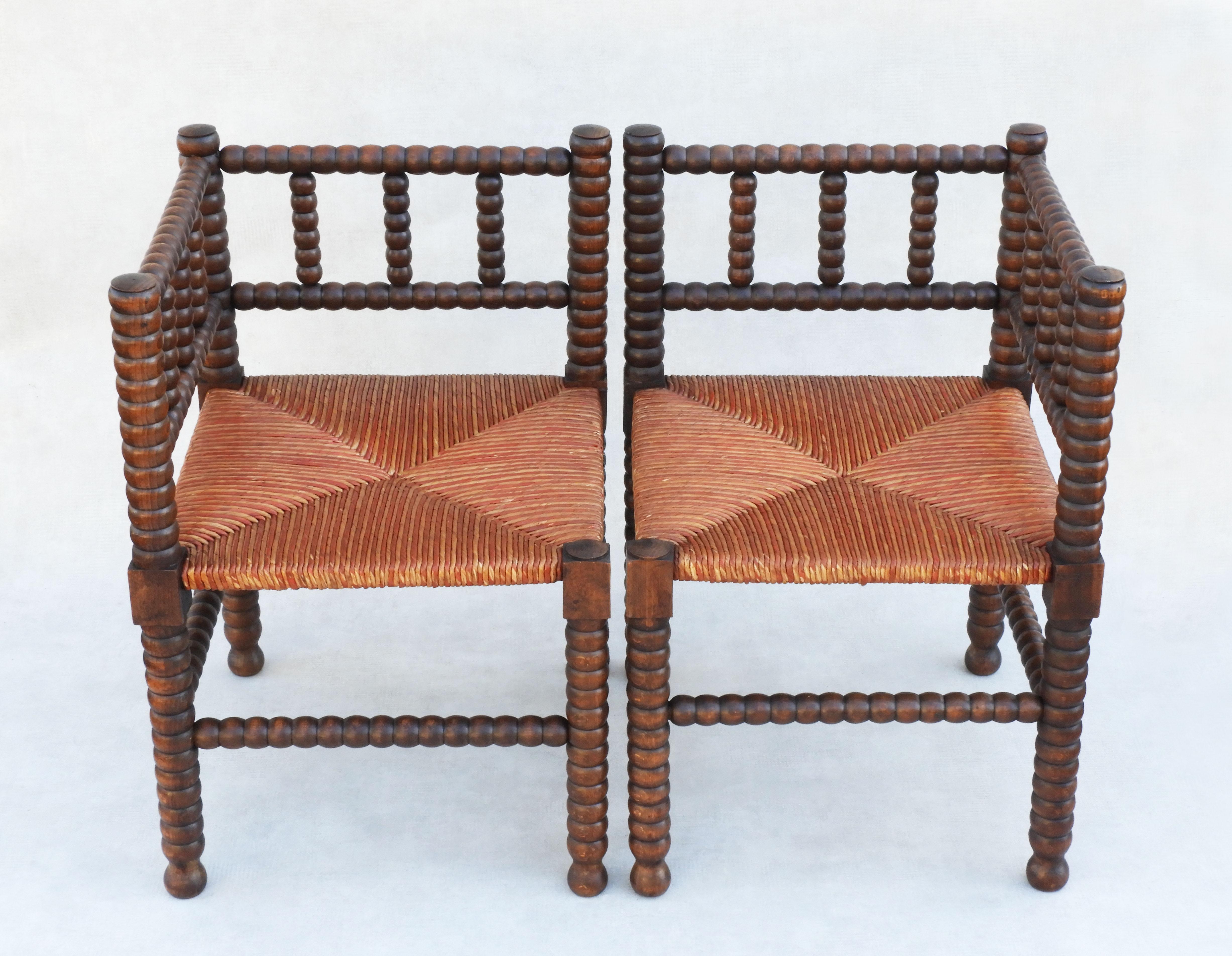 A charming pair of French Provincial bobbin wood corner chairs. Beautifully turned oak frames and original striped rush seats, sturdy and strong and in good antique condition. Stylish, eye-catching chairs would make a fabulous addition to any