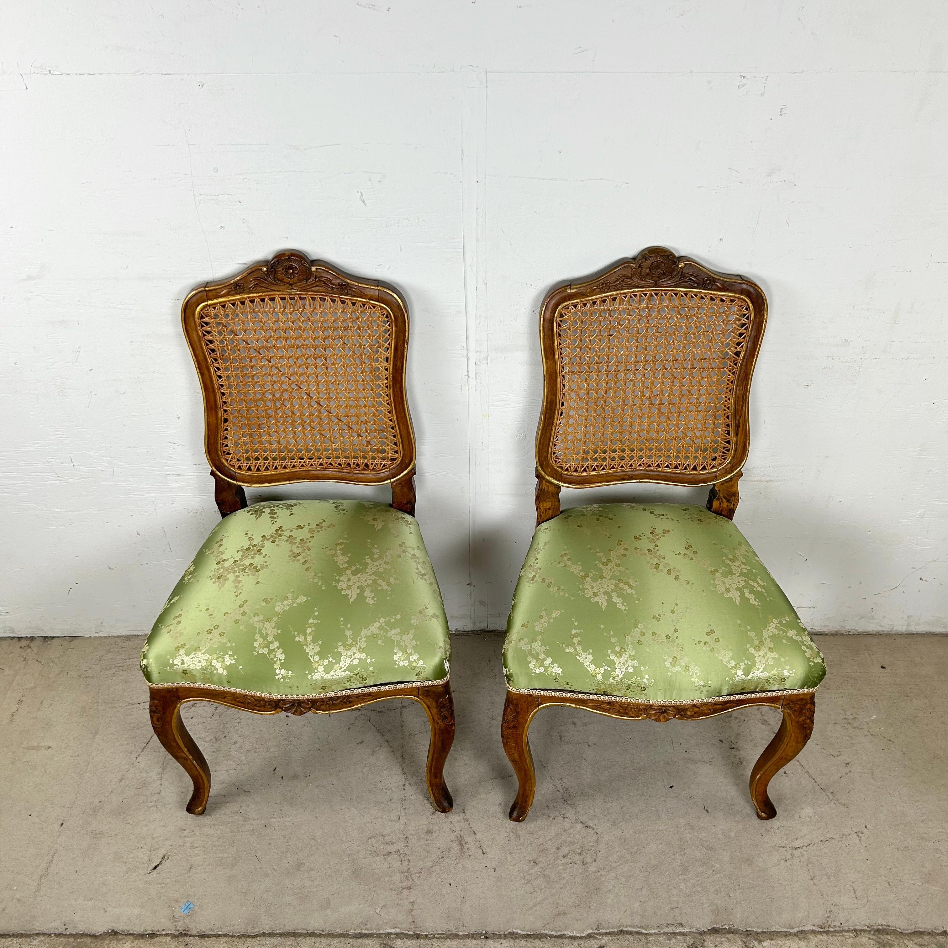 Esta exquisita pareja de sillas auxiliares de estilo Luis XV provincial francés data del siglo XX y muestra una artesanía magistral. Cada silla presenta un marco de nogal bellamente tallado, un respaldo de caña perfilado y asientos tapizados en