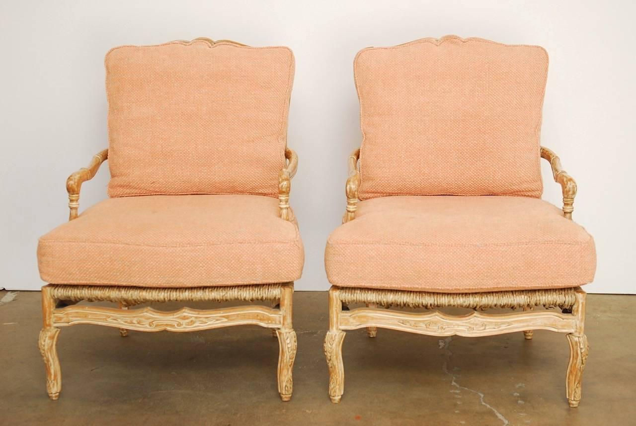 Bespoke pair of ladder back rush seat fauteuil armchairs or lounge chairs made in the French provincial style by William Switzer. Generous proportion frames hand made in Spain featuring a carved fruitwood finished in a white glaze. Fitted with deep
