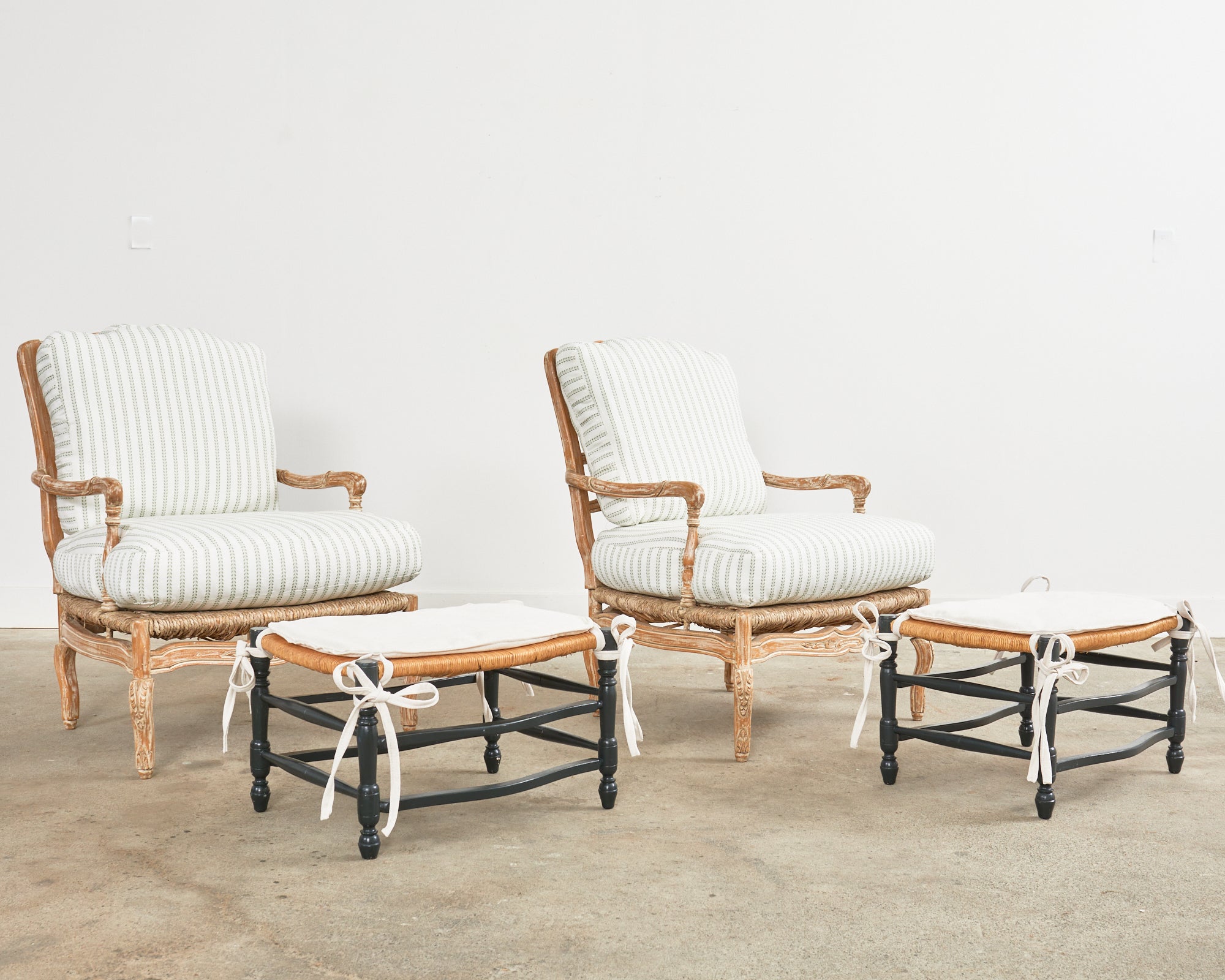 Bespoke pair of ladder back rush seat fauteuil armchairs or lounge chairs with an made in the French provincial style by William Switzer. Generous proportion frames hand made in Spain featuring a carved fruitwood finished in a white glaze. Fitted
