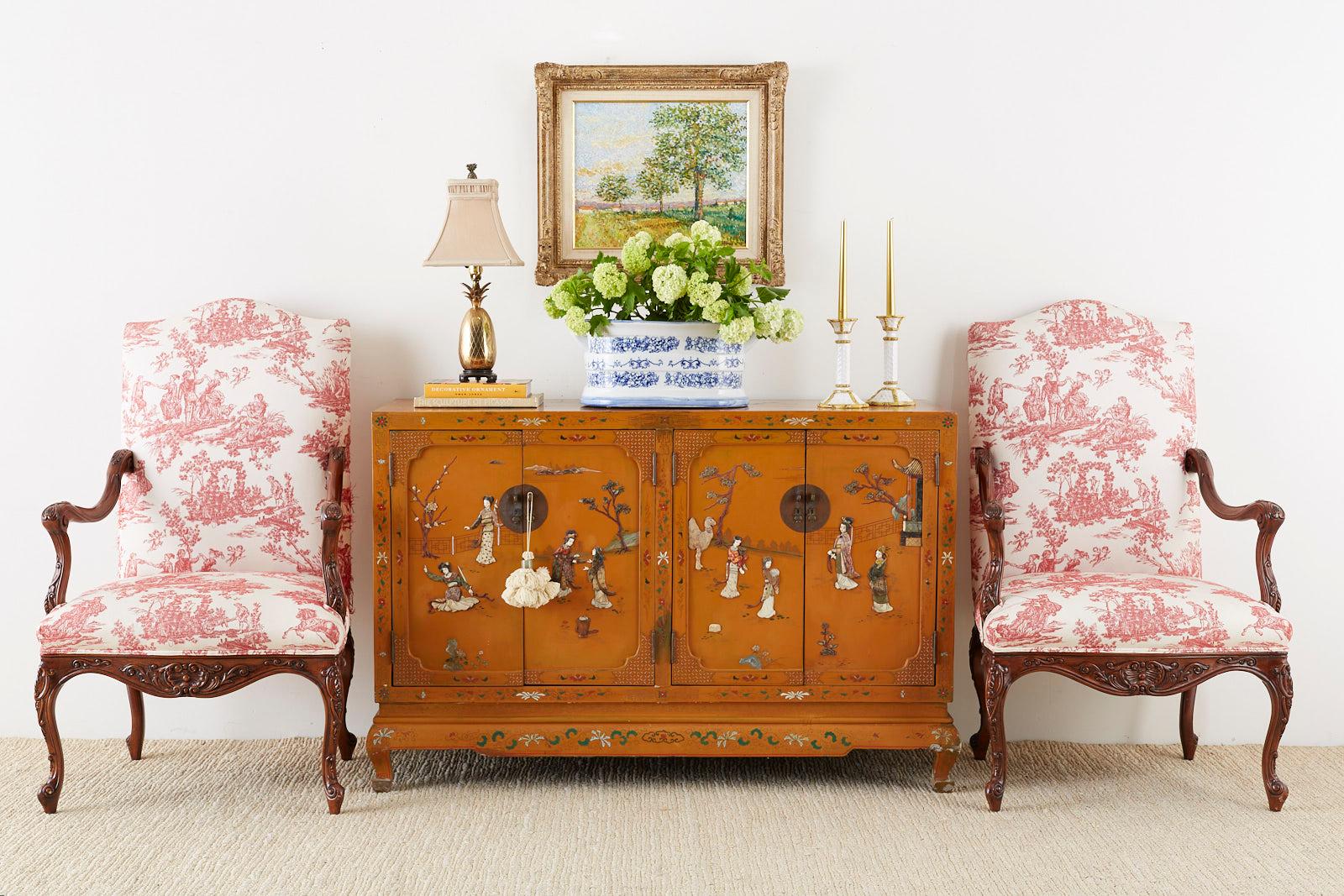 Impressive pair of carved walnut fauteuil armchairs or library chairs featuring a French Toile de Jouy upholstery. Made in the country French provincial style constructed from hand-carved English walnut frames with generous proportions. Elegant
