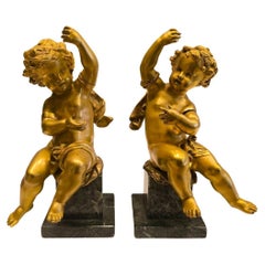 Pair of  French putti in gilt and chiseled bronze on a green marble base