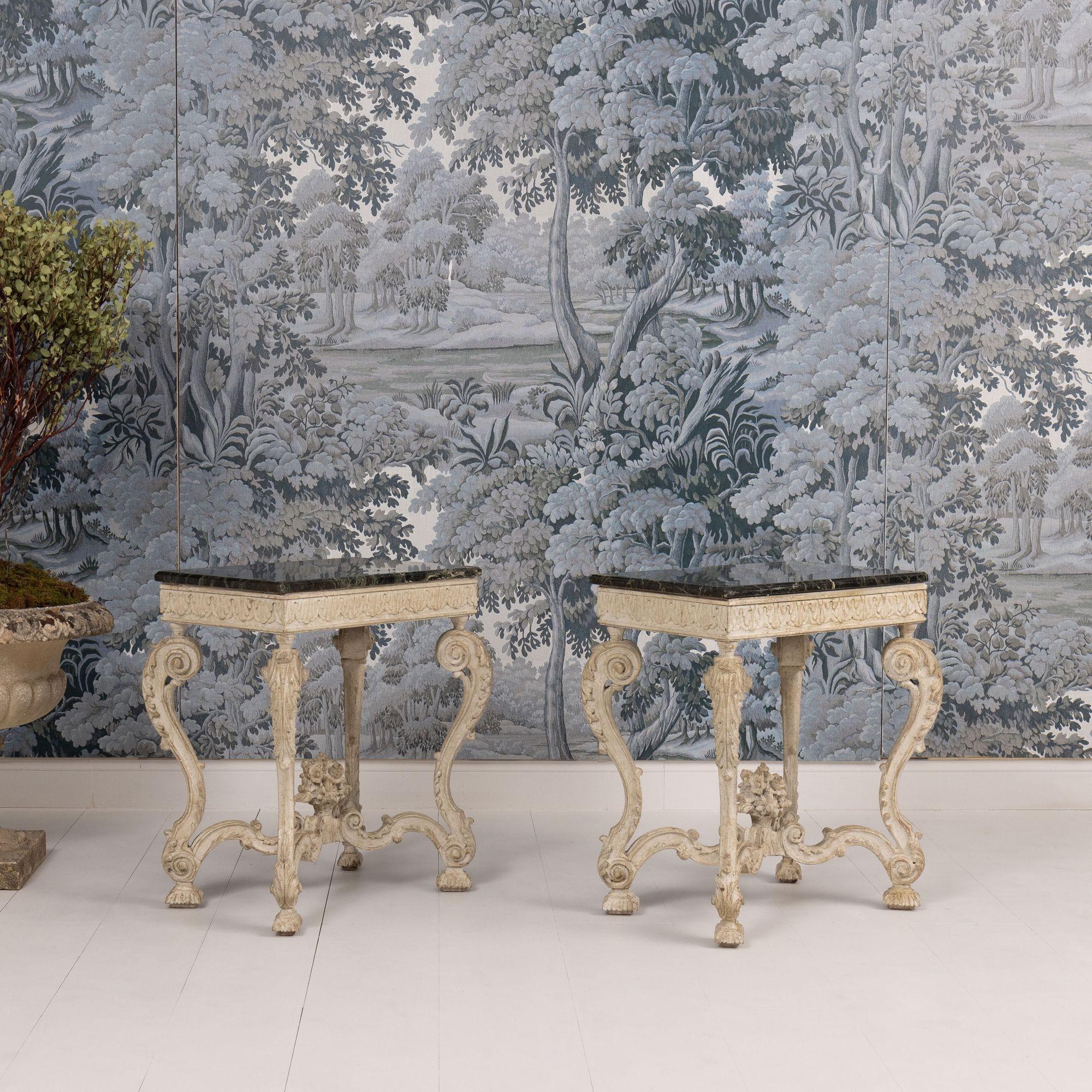 A beautiful pair of French Regency side tables with deep green Campan marble tops from a private home outside of Paris. Circa 1910.  Attributed to Maison Jansen. Elaborately carved apron, wood legs, and stretcher base joined by a carved basket of