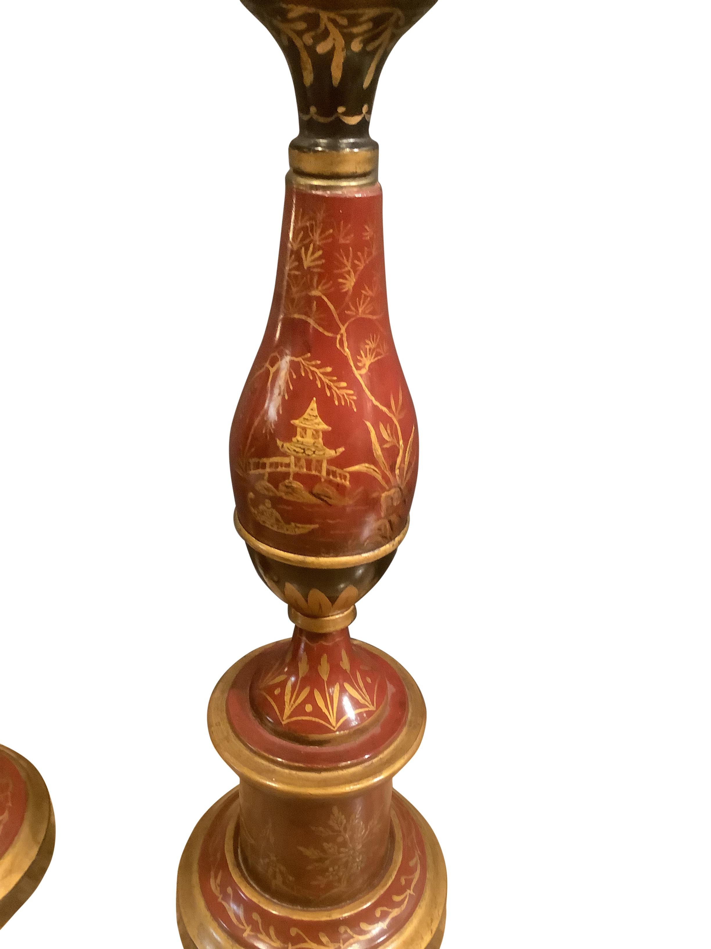 Gorgeous pair of French Chinoiserie decorated tole lamps with raised painted scenic and gilt decorations. Baluster form body on a round plinth base. The shade rest is adjustable to accommodate different size shades. Exceptional quality.
