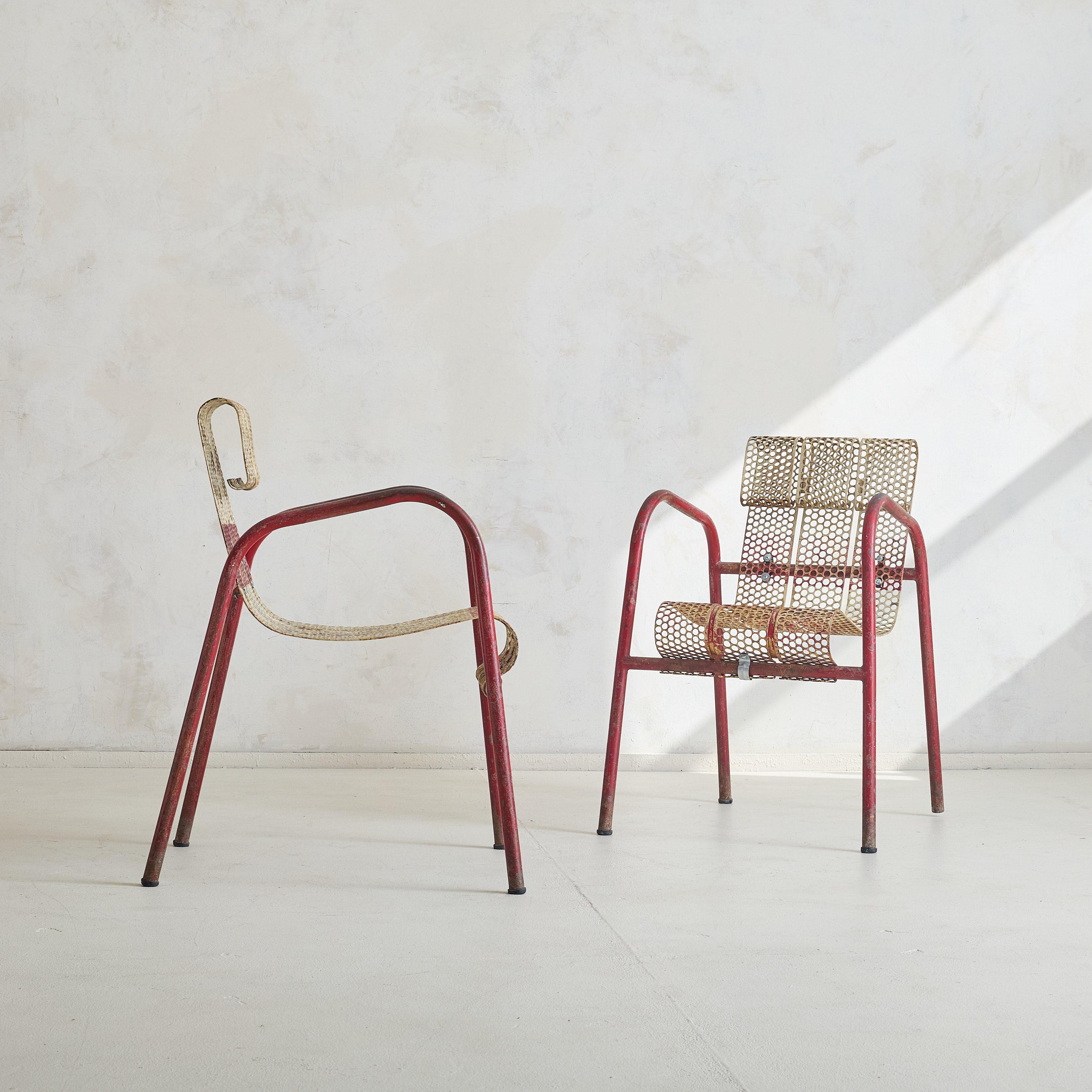 A rare pair of metal armchairs designed by Claude Adrien for Edition Meubles Artistiques Modernes (M.A.M.) in the 1950s. Capturing the spirit of mid-century French industrial design, they feature tubular aluminum frames with exaggerated, angled arms
