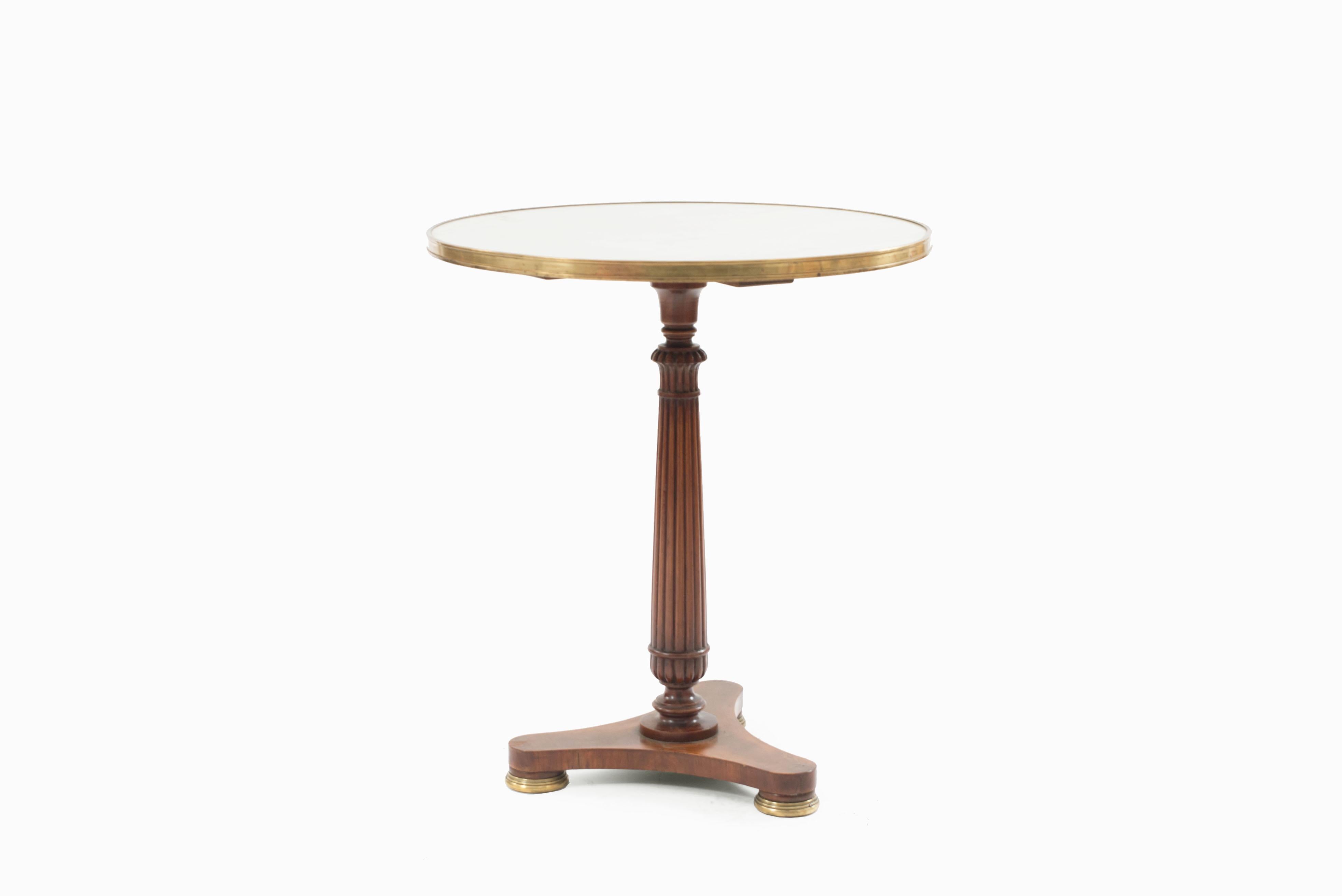 Pair of French Regence style mahogany end tables / guéridon with inset circular white marble tops, bronze binding, supported on fluted pedestal and resting on tripartite bases, circa 1950.