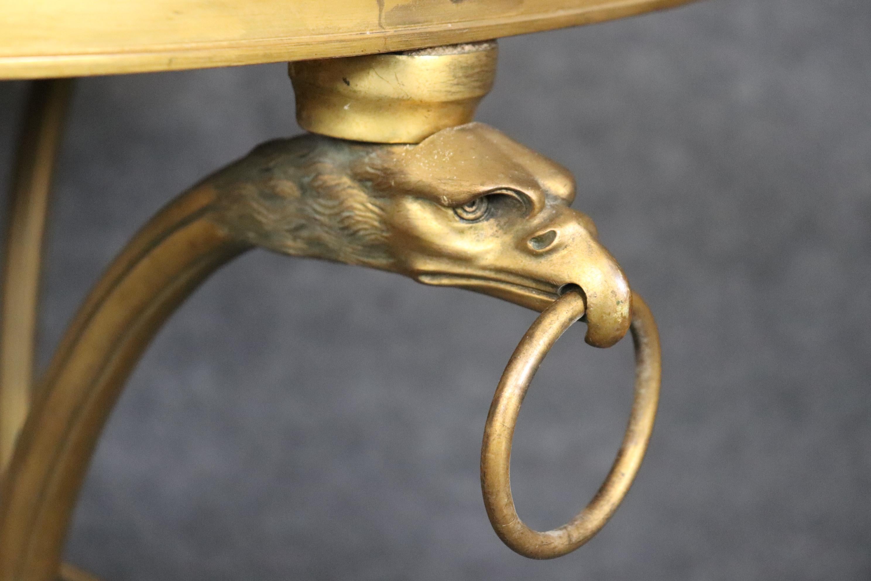 This is a fine pair of bronze eagle head and ring Directoire or Regency style French gueridons. The gueridons are made of heavy solid bronze or possibly brass though we think they are bronze. The tables feature gorgeous castings of eagles wih rings