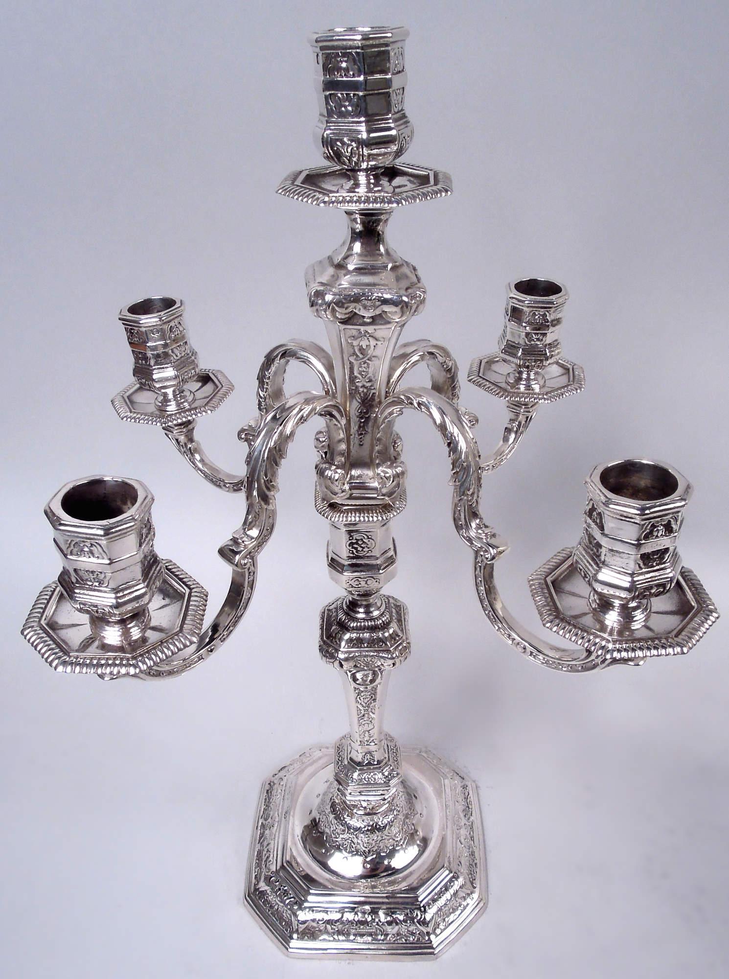 Paire de candélabres à 5 lumières en argent 950 de style Renaissance française, vers 1950. Chacun : Socle à cire et à douille, ceinturé et ventru, sur une tige de pilier sur laquelle sont montés quatre bras à volutes et coiffés d'une feuille, chacun