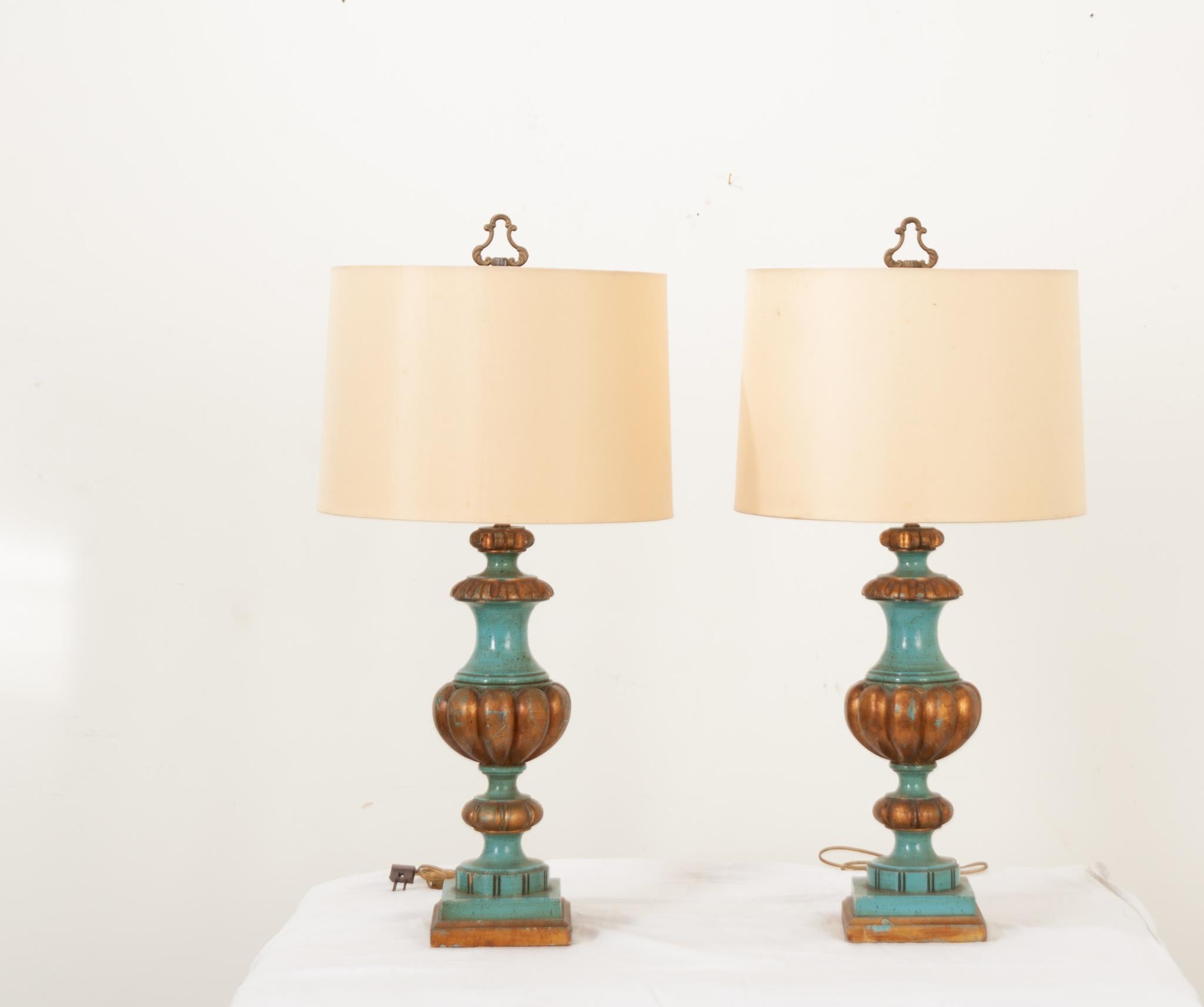 A pair of hand-painted turned wood column lamps made in France. Each lamp’s body showcases an intricately turned silhouette and a warm brown and teal finish for a unique design. The shade has been gently used and does have some wear. Professionally