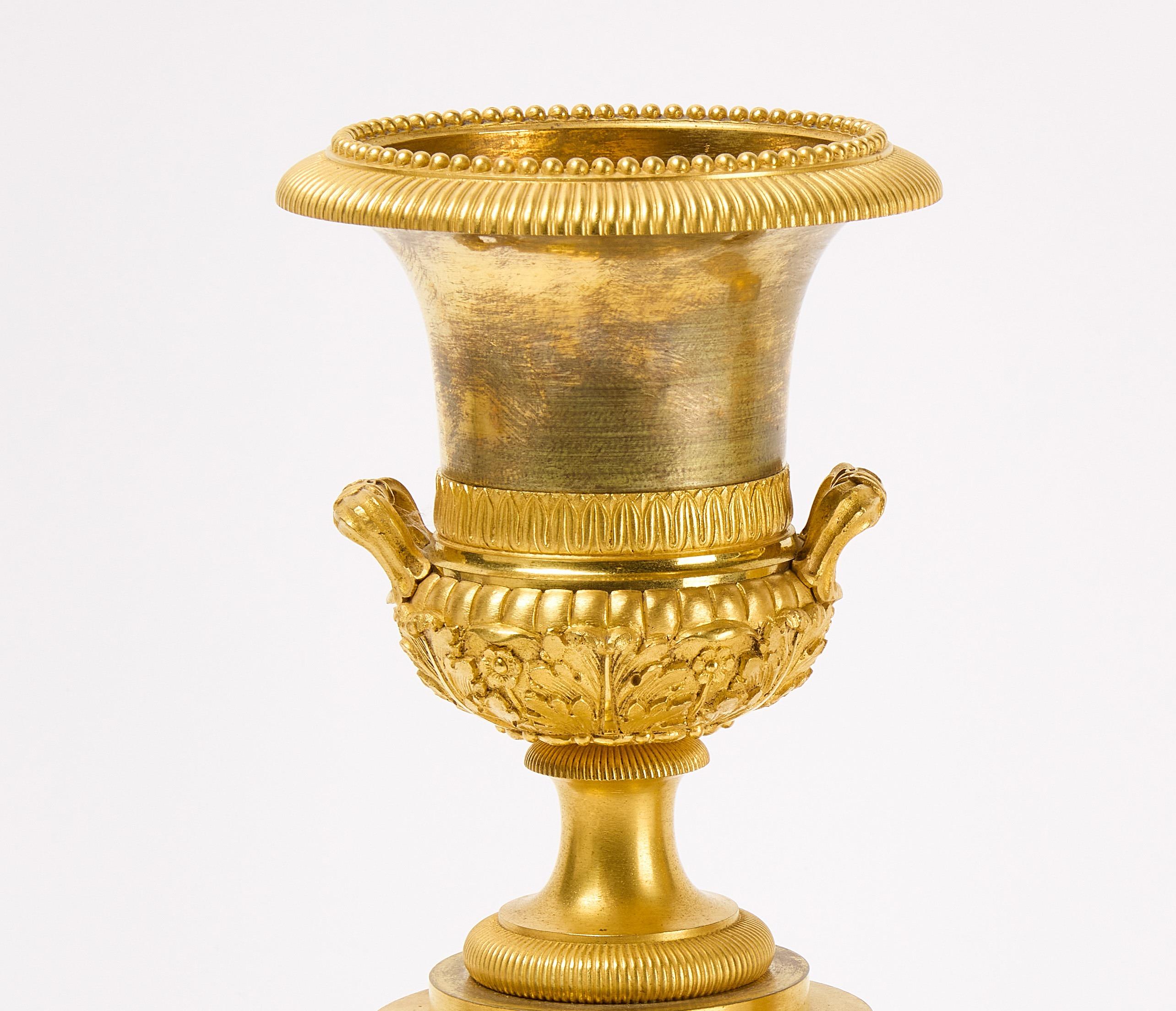 Ein Paar vergoldete Medici-Bronze (Ormolu) aus der französischen Restaurationszeit, Vasen oder Kerzenständer mit fein eingeschnittenen Details und einem Dekor aus wabenförmigen Rosetten und Akanthusblättern.  Exquisite Proportionen.  Circa 1830.