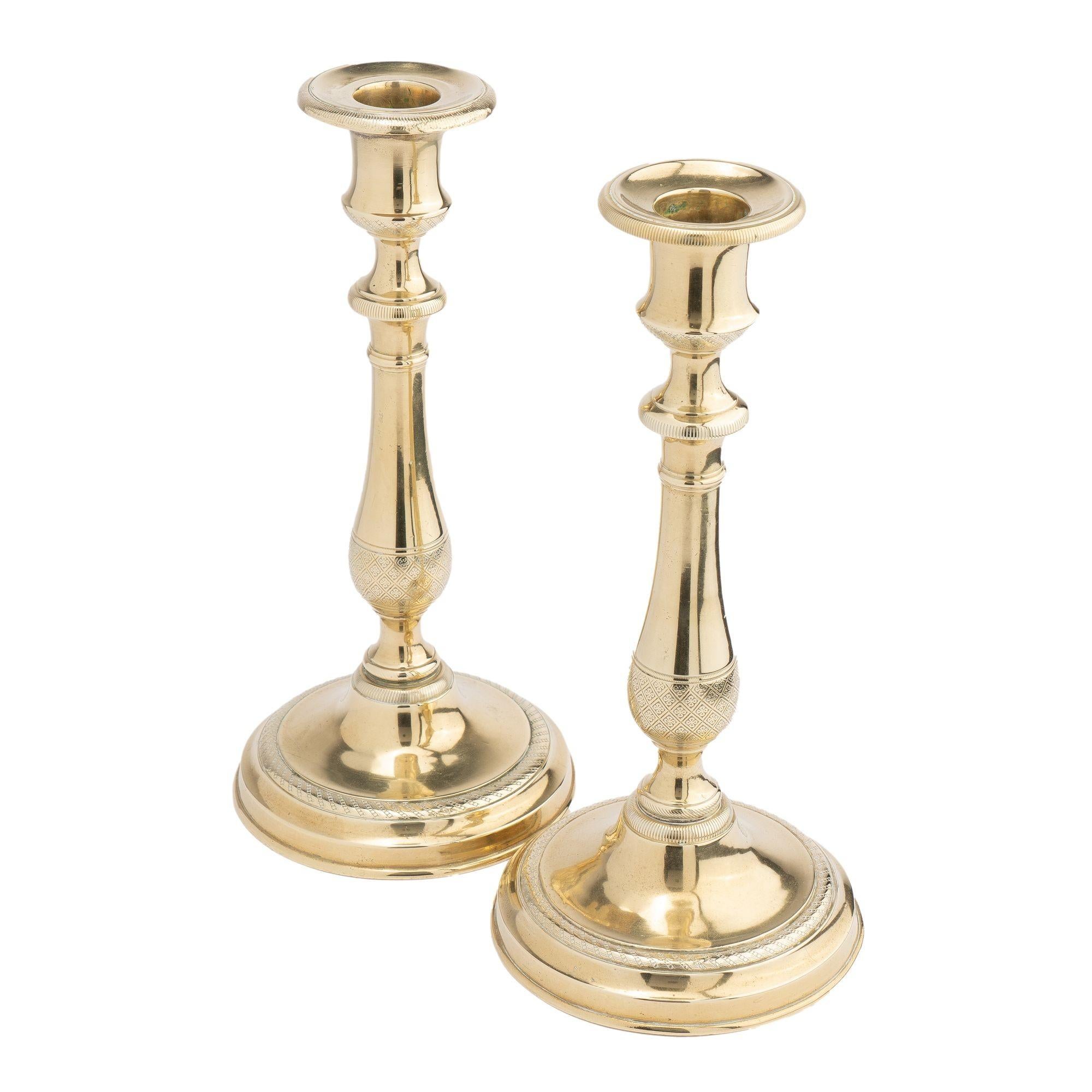 Pair of French Restoration cast brass, engine turned candlesticks on circular bases.

France, circa 1815.