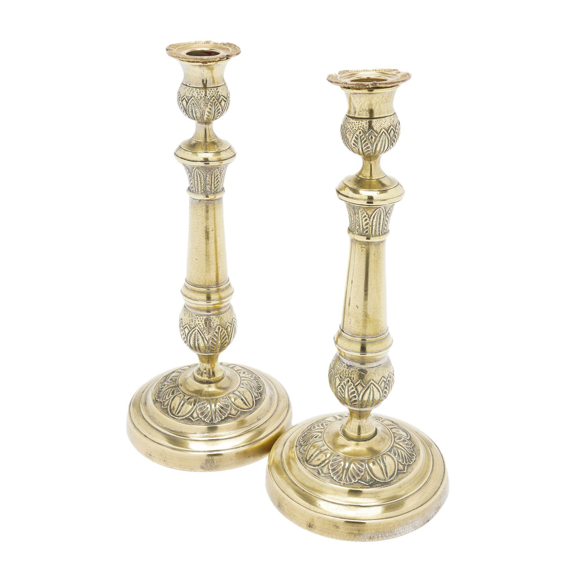 Coppia di candelieri in ottone fuso del periodo della Restaurazione francese. Il fusto della candela è collegato alla base circolare a cupola e gli elementi classici a fogliame poco profondo sono visibili sulla coppa della candela, sul fusto