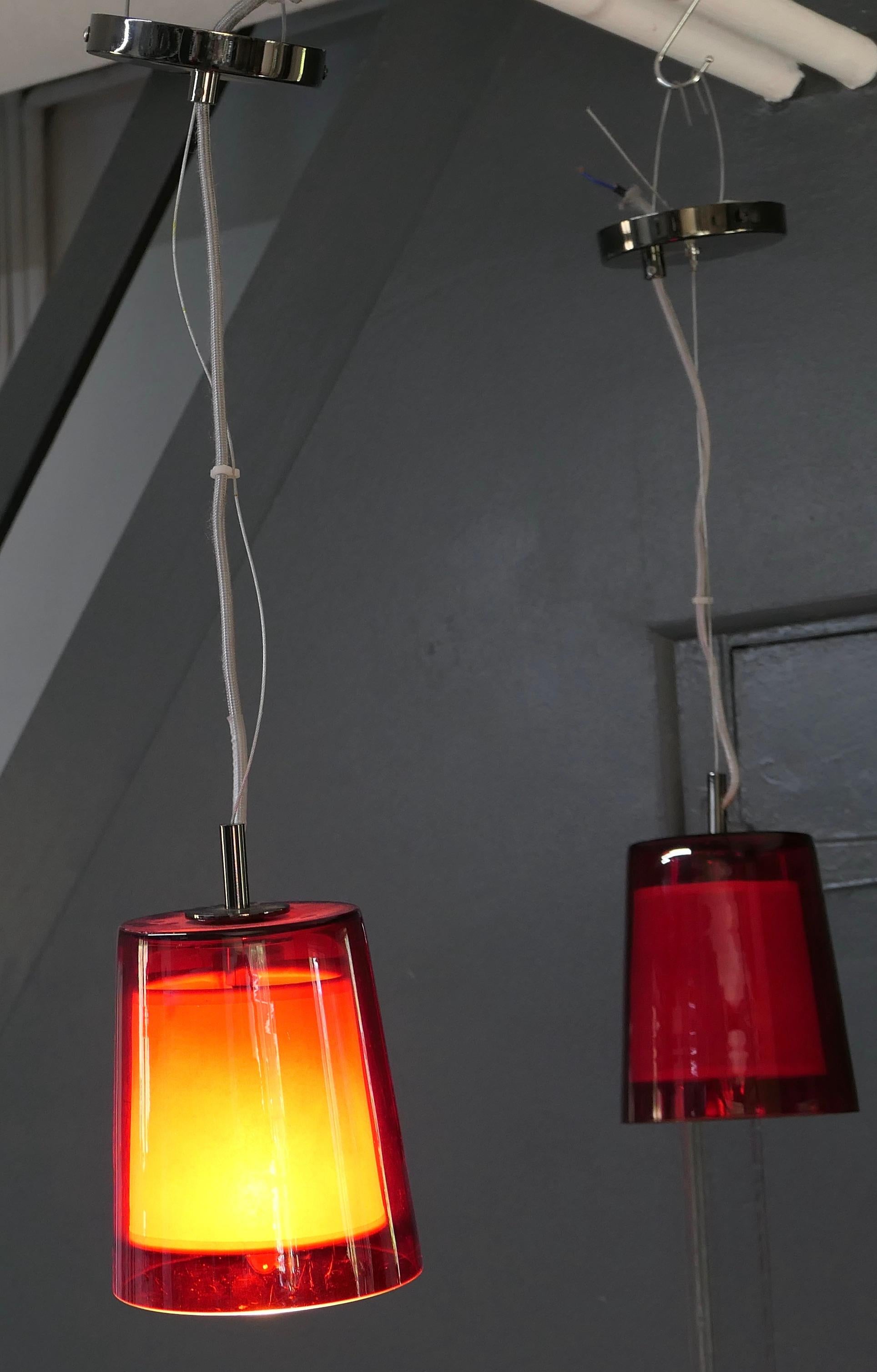 Pair of French Retro red cafe ceiling lights.

A Pair of French Cafe lights from the 1960s, with red glass shades lined with white canvas, a great look from the 1960s
The lights are working and will need an electrician to install them.
The