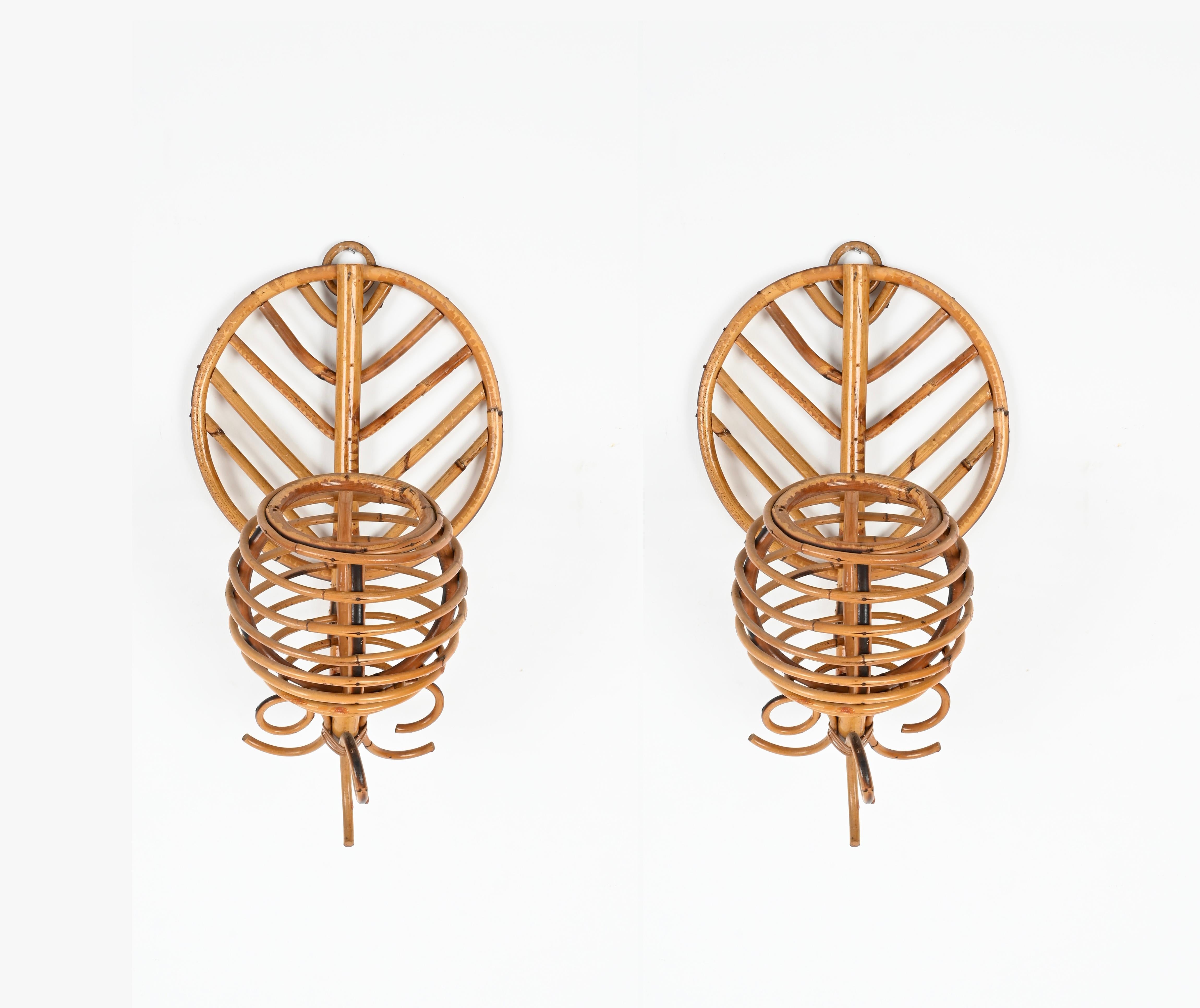 Stunning pair of Mid-Century French Riviera wall lamps fully made in curved rattan and hand-woven wicker. These fantastic lamps were produced in the 1960s in France and are attributed to Louis Sognot. 

These lovely sconces are in amazing conditions