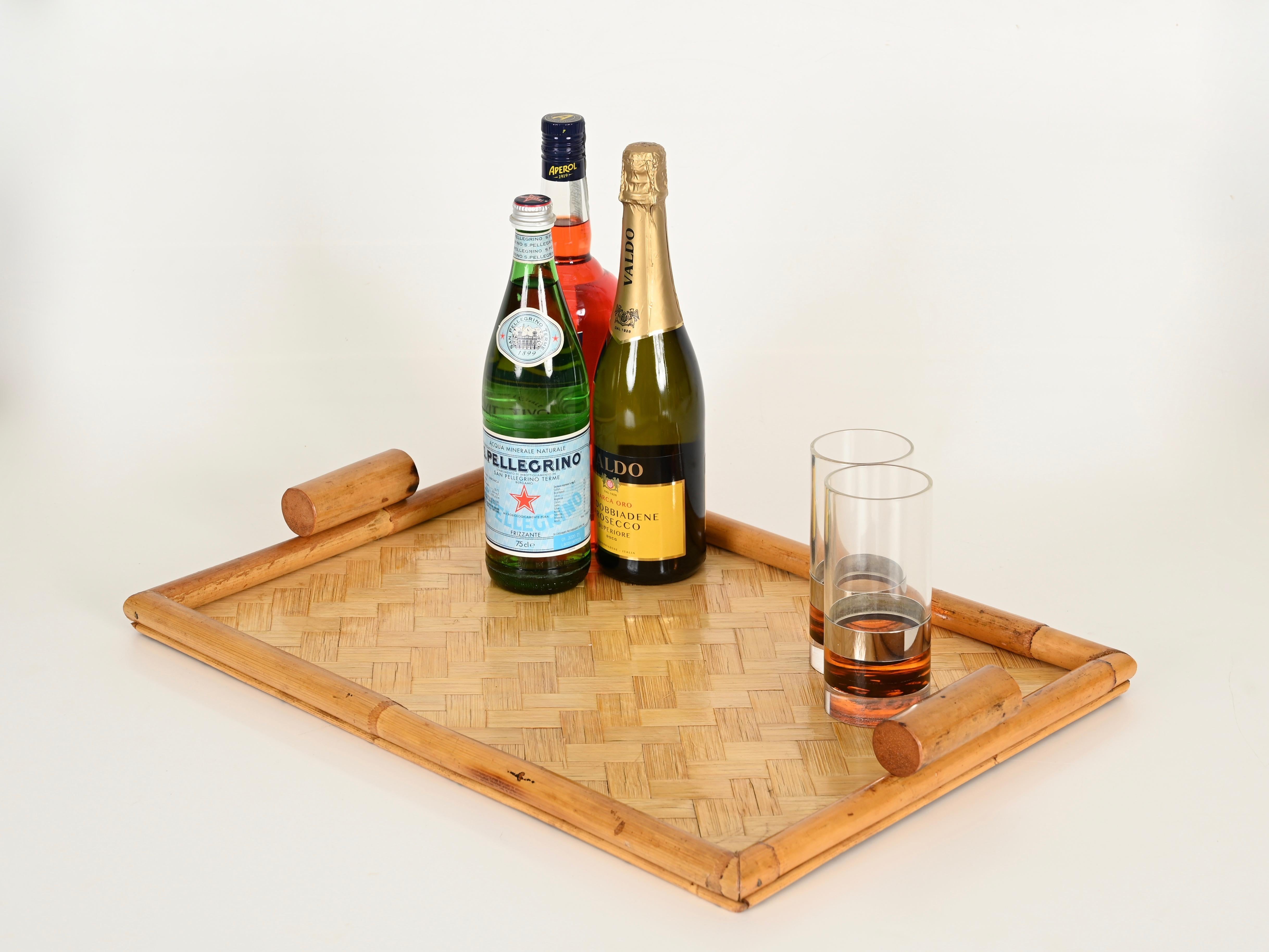 Wonderful pair of French Riviera style serving trays in bamboo and woven rattan. These stylish and unique organic trays were made in Italy during the 1960s. 

The trays are in amazing condition and with a charming honey color. The frame and the