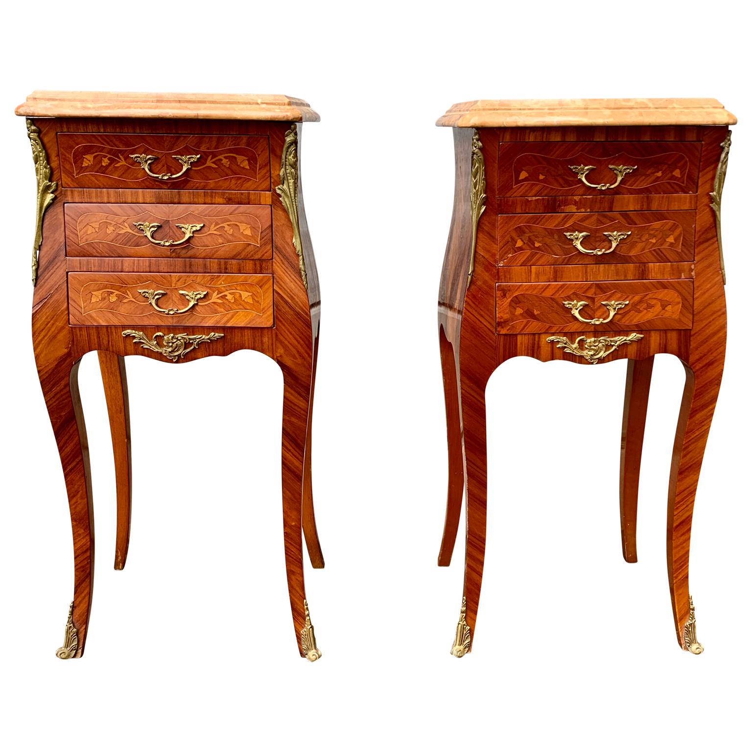 A pair of French bomb shaped nightstands or small chest of drawers in mahogany marquetry work and top in mottled pink marble.
This pair of small 3 drawers Rococo style bedside commodes with original brass handles and decorations are from the early