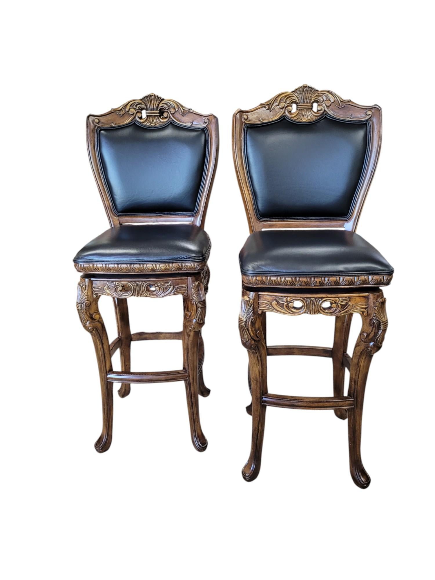 These Louis XV Revival style bar stools blend 18th-century elegance with modern functionality. Crafted from solid birch, the frames feature gracefully curved cabriole legs and intricate carvings of acanthus leaves, and prominent rocaille shell