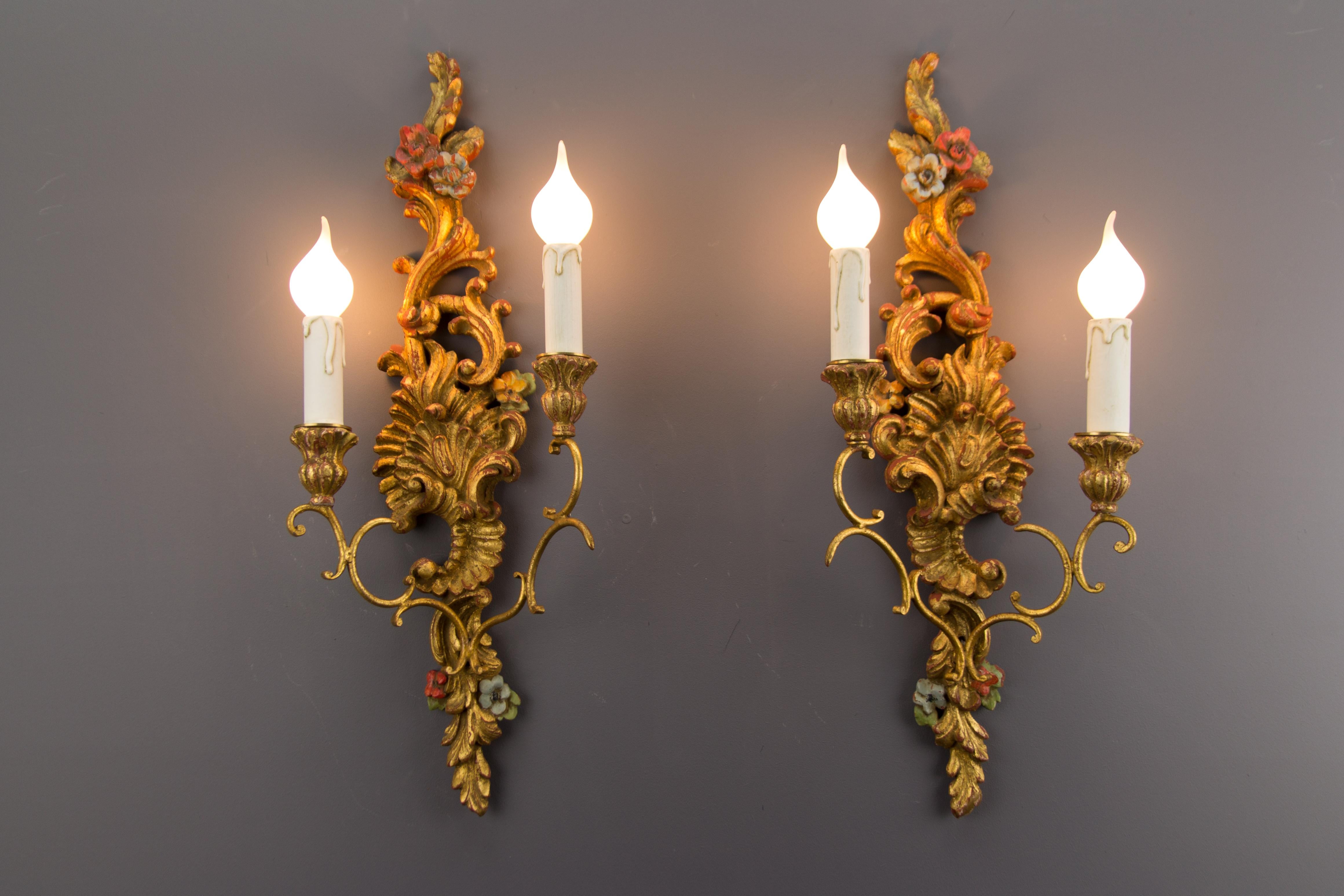 A pair of beautiful French Rococo-style polychrome painted and carved wooden and metal two-light sconces with floral patterns. Each wall light has two sockets for E14-size light bulbs.
Dimensions: height 60 cm / 23.6 in; width 23 cm / 9.05 in; depth