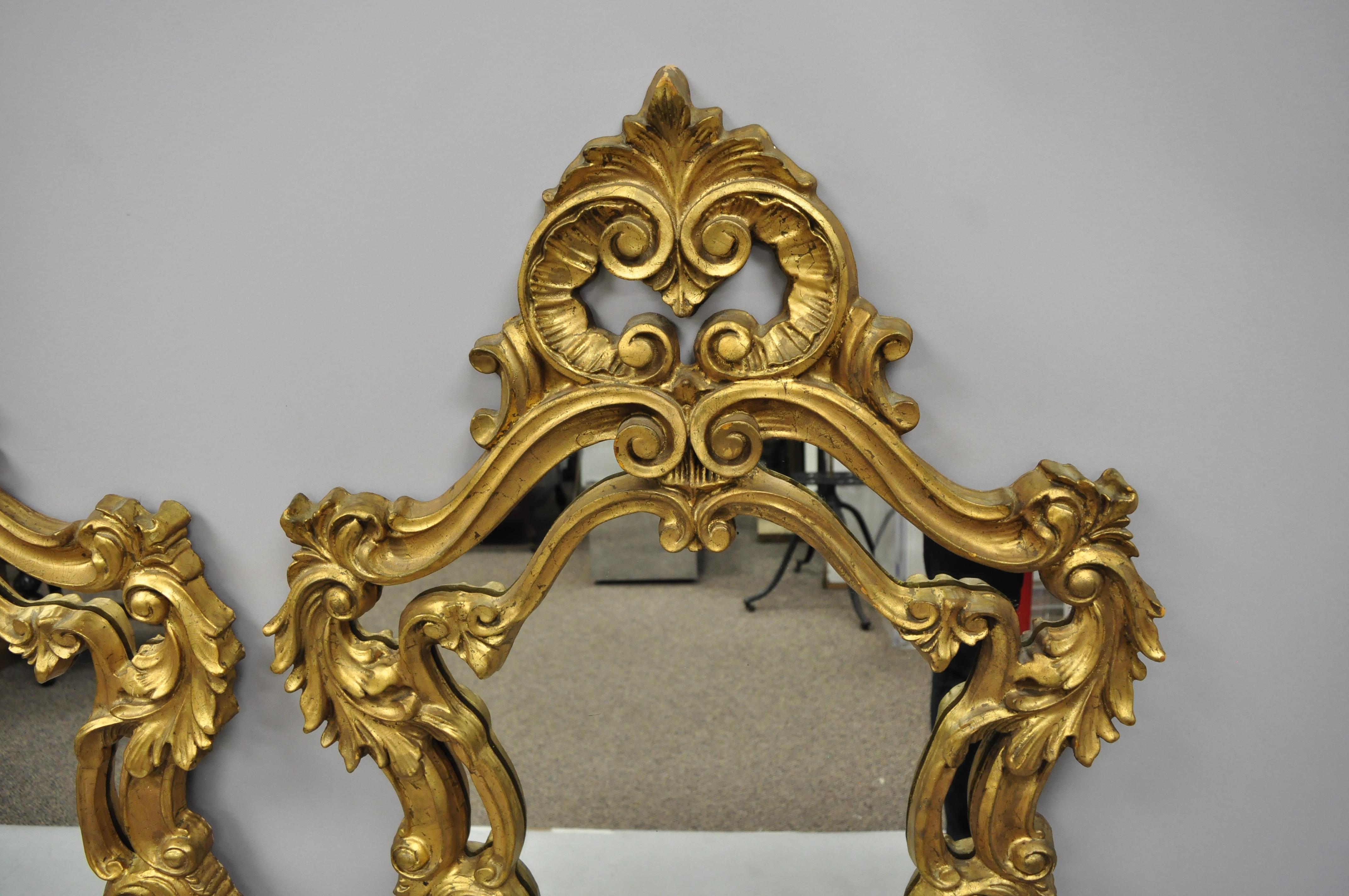 Pair of French Rococo style gold wall mirrors with fancy scroll work. Items feature fancy molded foam Rococo style frames, leafy scrollwork and pierced crest central mirror with exposed mirror border, very nice vintage item, great style and form,