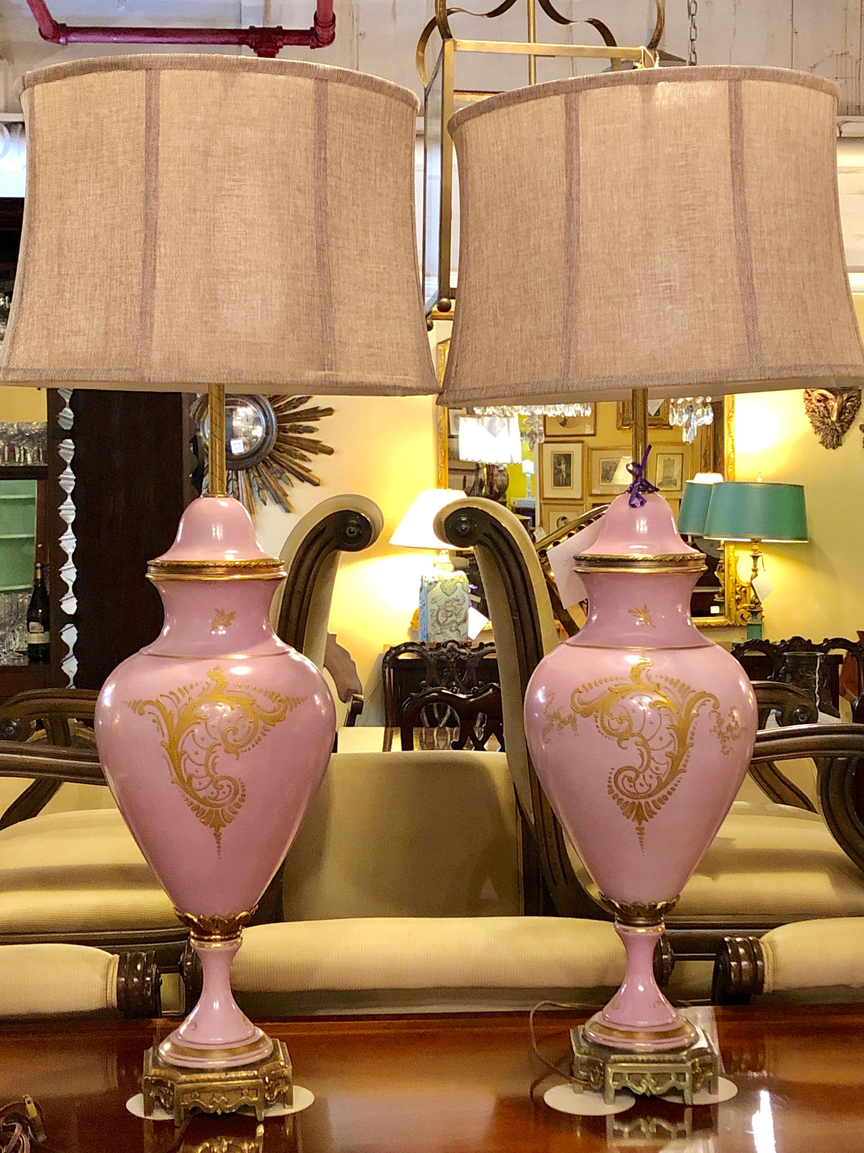 Pair of French Sevres marked monumental pink urn table lamps both signed Gillet. This Fine pair of hand painted lidded urns have been meticulously mounted as table lamps both bearing the Sevres mark on the base as well as the made in France wording.