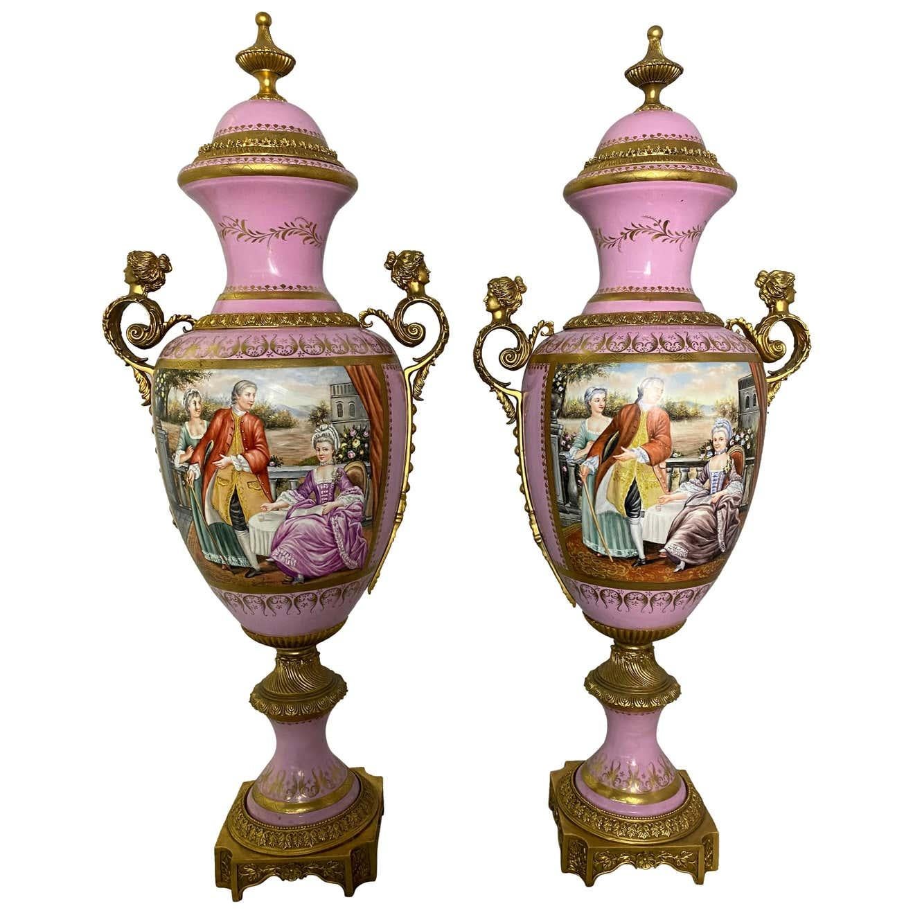 A pair of French Sèvres style monumental pink vases with hand painted scenes depicting noble French lovers dining on a garden table.

Dimensions: (cm) H 104/ W 46/ D 46.