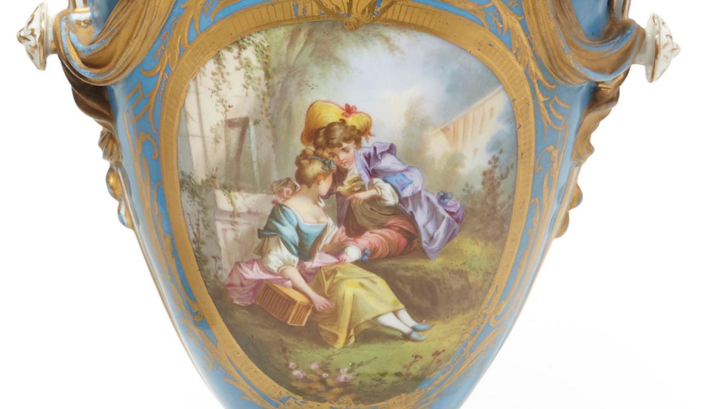 Attractive 19th century pair of French Sèvres style porcelain two handled vases.

The two gilt flying playful cherubs holding wreaths are applied to the Bleu Celeste porcelain neck, above an ovoid body painted on both sides, the front is centered