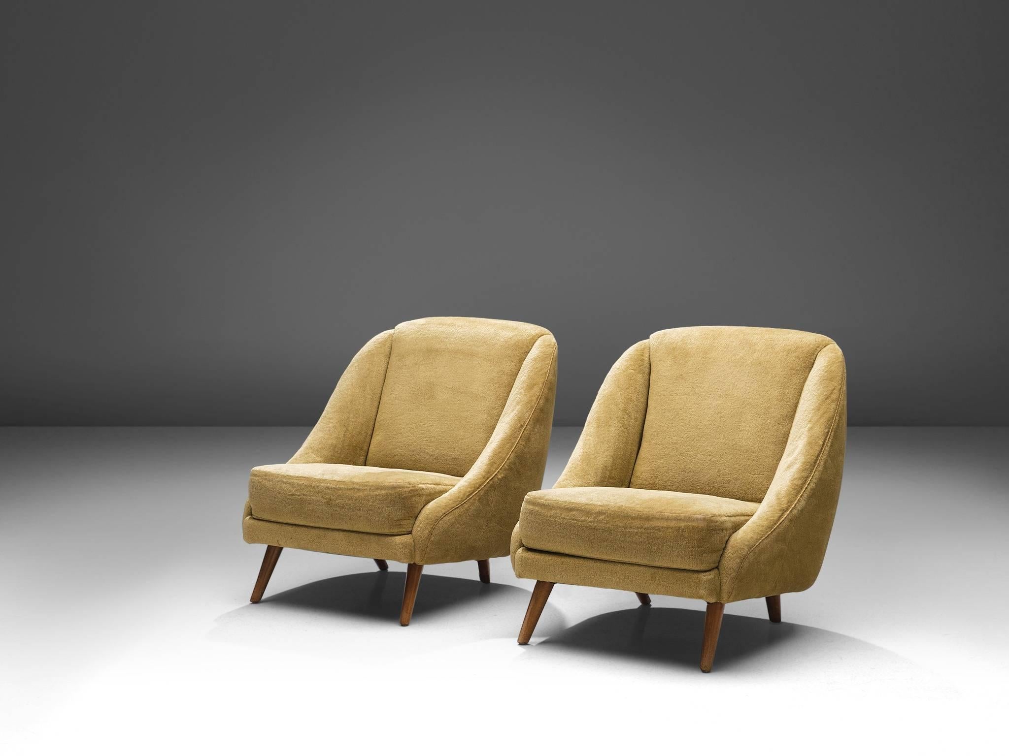 Pair of armchairs, beige fabric, beech, France, 1950s. 

These elegant lounge chairs are designed by a French cabinet maker. The item holds simplistic design, with stunning aesthetic details. The chair is soft and rounded with sloping armrest. The