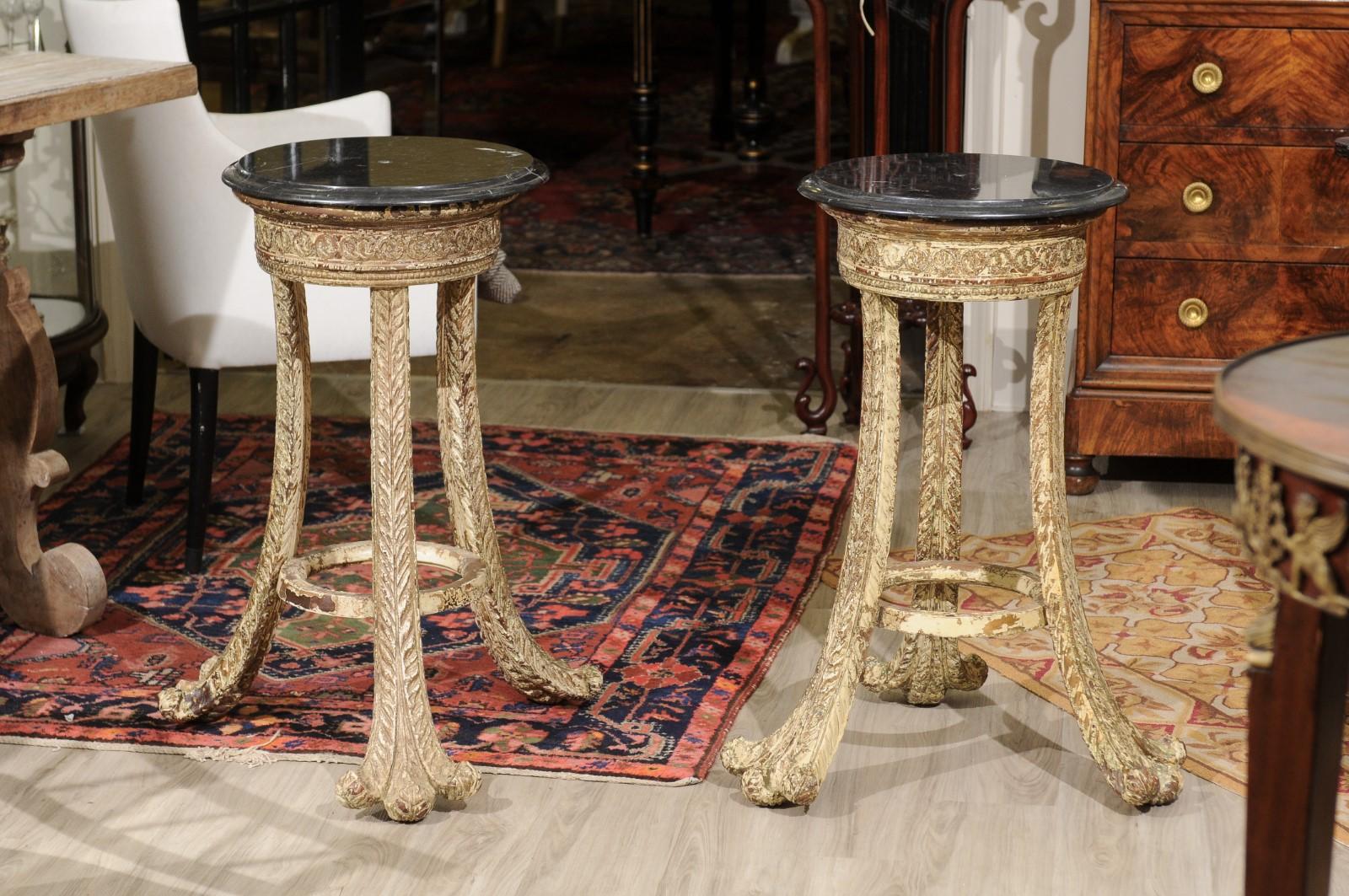 This pair of polychrome acanthus leaf tables could be used for a variety of things in a variety of places. A 16 inch black marble top sits on the heavily carved base. The feet of the 3 legs flare to a 23 inch diameter.