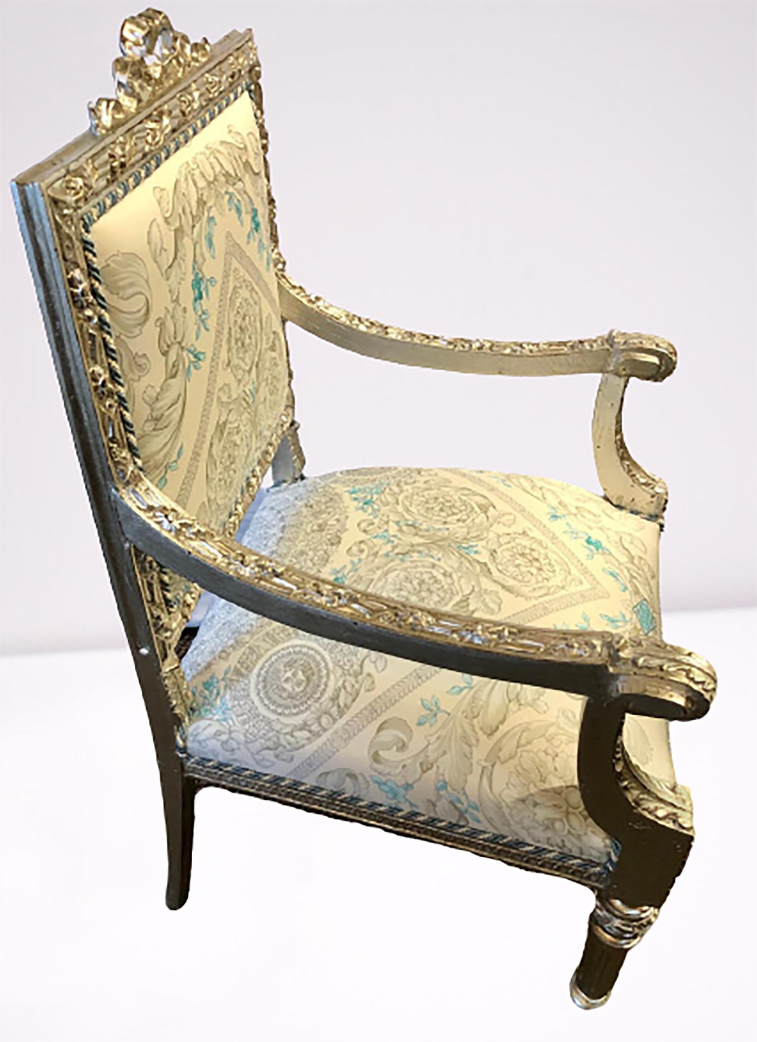 Stunning Pair of French silver gilt 19th century / 1920s Louis XVI style armchairs upholstered in Versace fabric. These incredible late 19th or early 20th century frames are simply carved terminating in bow and ribbon crests. The whole on Louis XVI