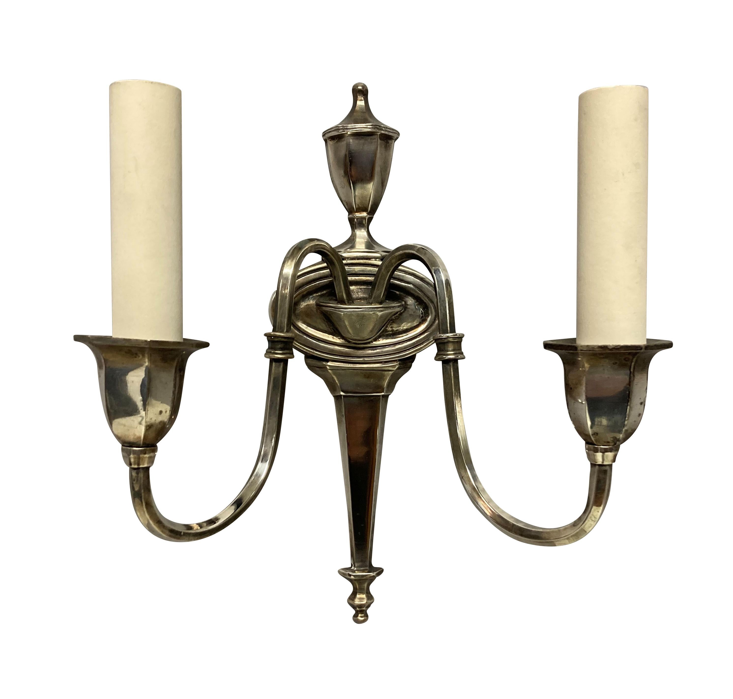A pair of French silver plated twin branch wall lights in a Neo-Classical manner.