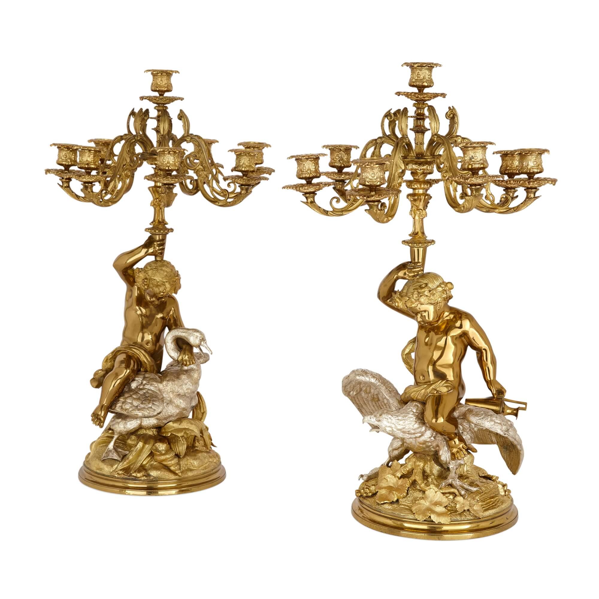 Pair of French silvered and gilt bronze candelabra 
French, Late 19th Century
Height 64cm, width 37cm, depth 37cm

Crafted in the 19th century, this pair of French candelabra exudes unmatched elegance, with their central decorative figures drawing