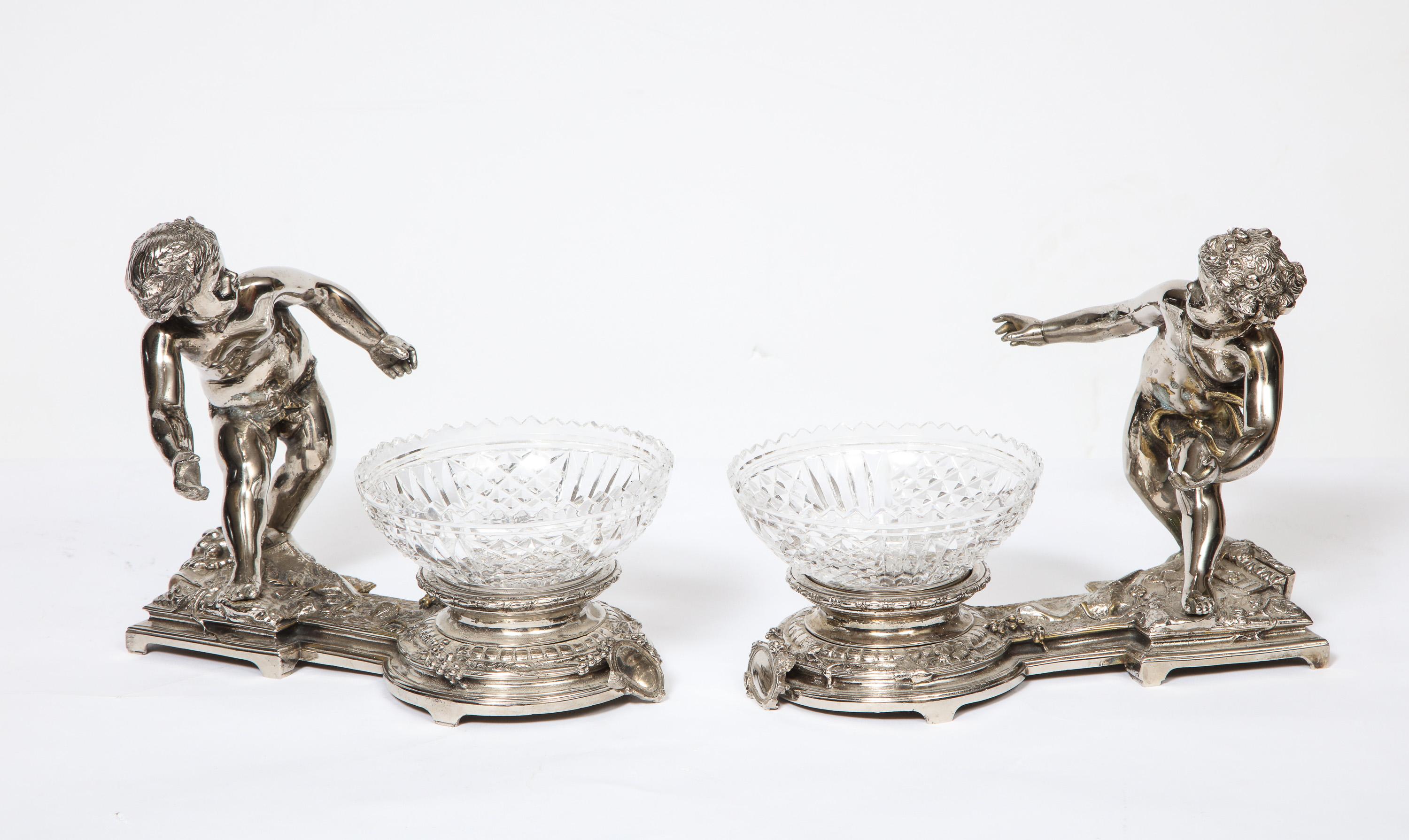 Pair of French silvered bronze and glass centerpieces with cherubs, attributed to Chirstofle, Paris.

Very charming pair of centerpieces / candy dishes and very good quality - would look good on any table.

Measures: 7