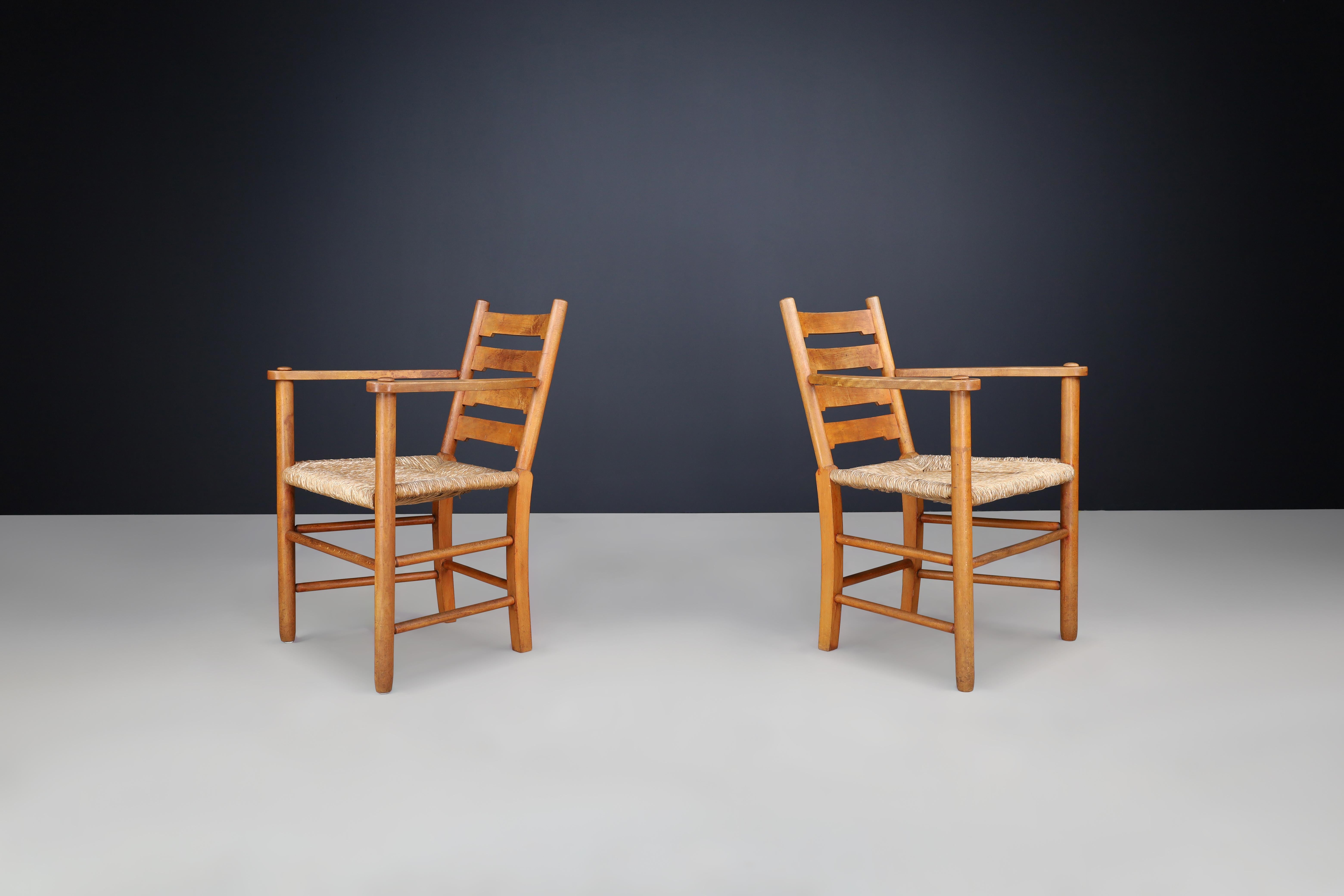 Pair of French Solid Beech Ladder-Back Armchairs with Rush Seats, France, 1950s

This elegant pair of ladder-back armchairs originates from France and dates to the 1950s—a decade celebrated for its refined craftsmanship and commitment to enduring