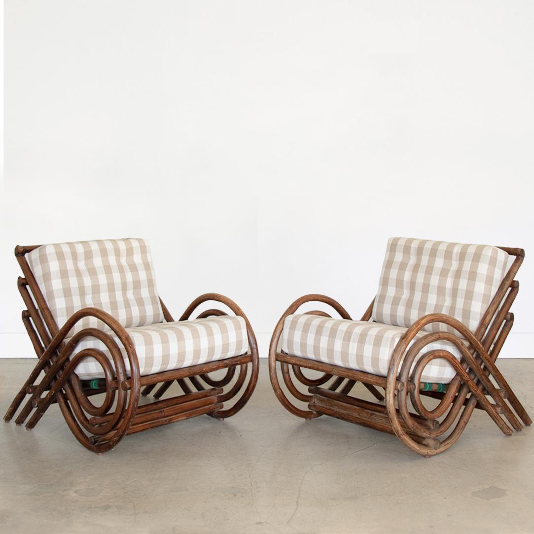 Incredible pair of rattan spiral lounge chairs from France, 1970's. Beautiful spiraled rattan arms and slatted back. Original dark brown coloring with leather wrapped ties on corners. New cushions upholstered in a neutral linen/ cotton plaid. Rare