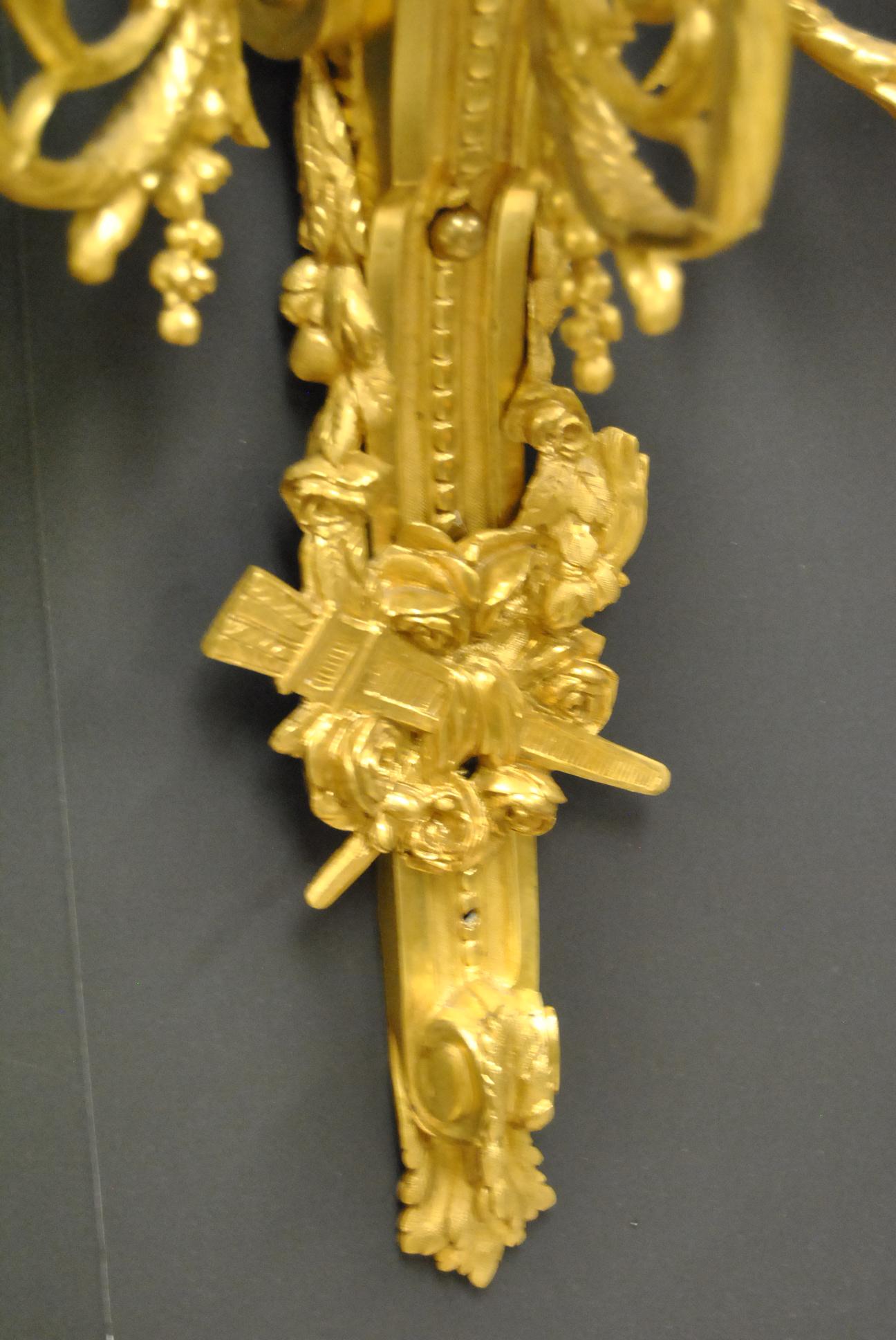 Inconnu Paire d'appliques de style français à trois bras en bronze doré avec détails de fruits et de fleurs en vente