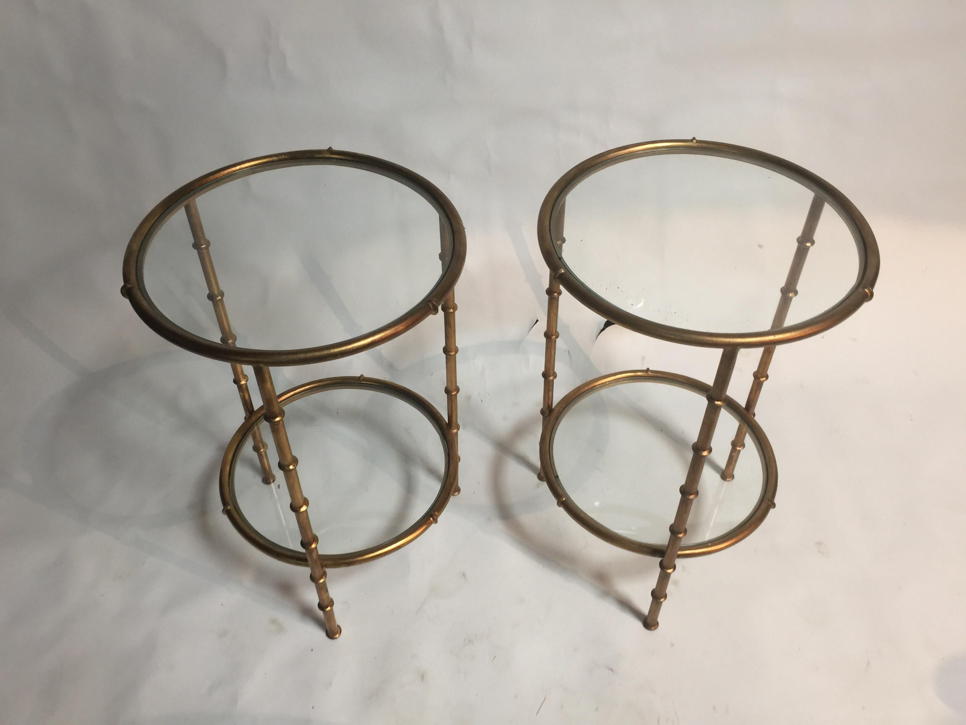 A pair of French-style gilt metal end tables with glass tops and lower shelves, circa 2000.

Dimensions:
15.75 inches W
24.5 inches H
7 inches H to floor between lower shelf and floor.