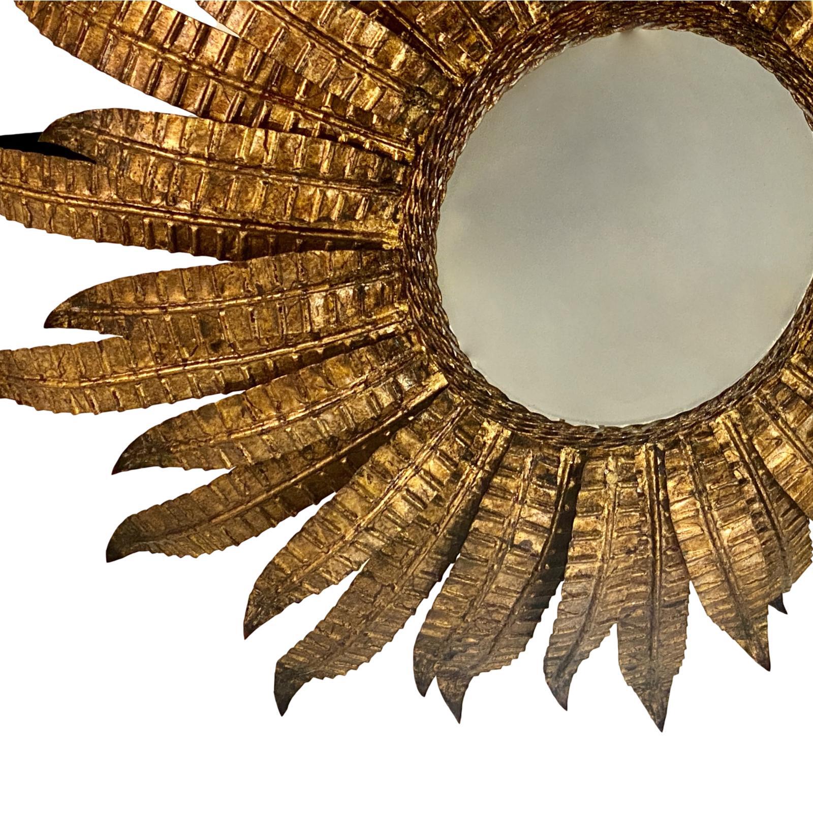 A pair of French circa 1960s gilt metal sunburst light fixtures with orignal patina and four interior lights. Sold individually.

Measurements:
Diameter 24