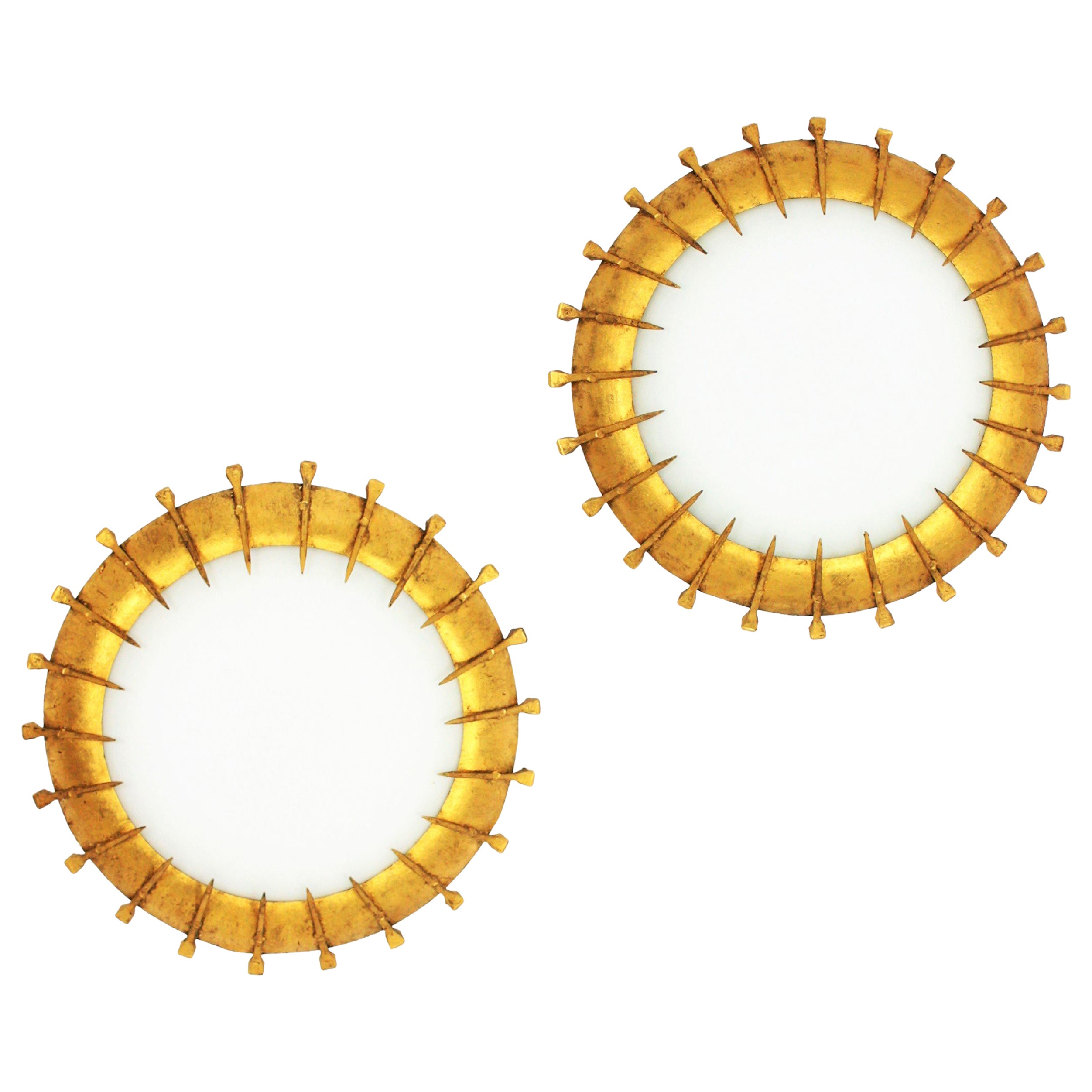 Elégantes montures encastrées en fer doré et verre opalin avec décor de clous et finition à la feuille d'or. France, années 1940-1950.
De belles pièces à placer seules mais aussi intéressantes mélangées à d'autres luminaires de cette manière pour