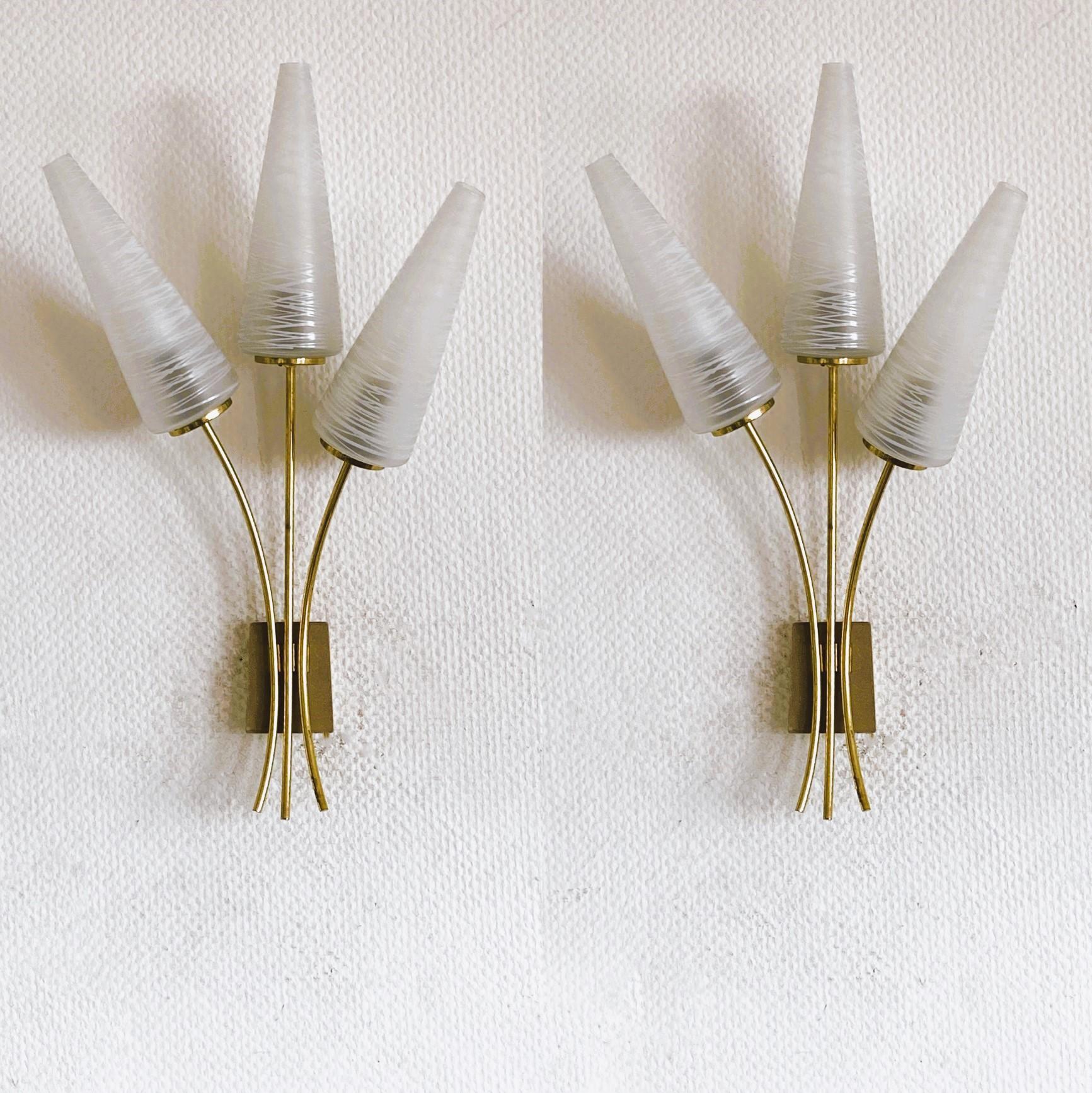 Une grande paire d'appliques murales à trois bras fabriquées en France par la célèbre Maison Arlus dans les années 1950. Design/One très élégant et intemporel, en forme de bouquet de tulipes en laiton avec de beaux et grands abat-jours en verre