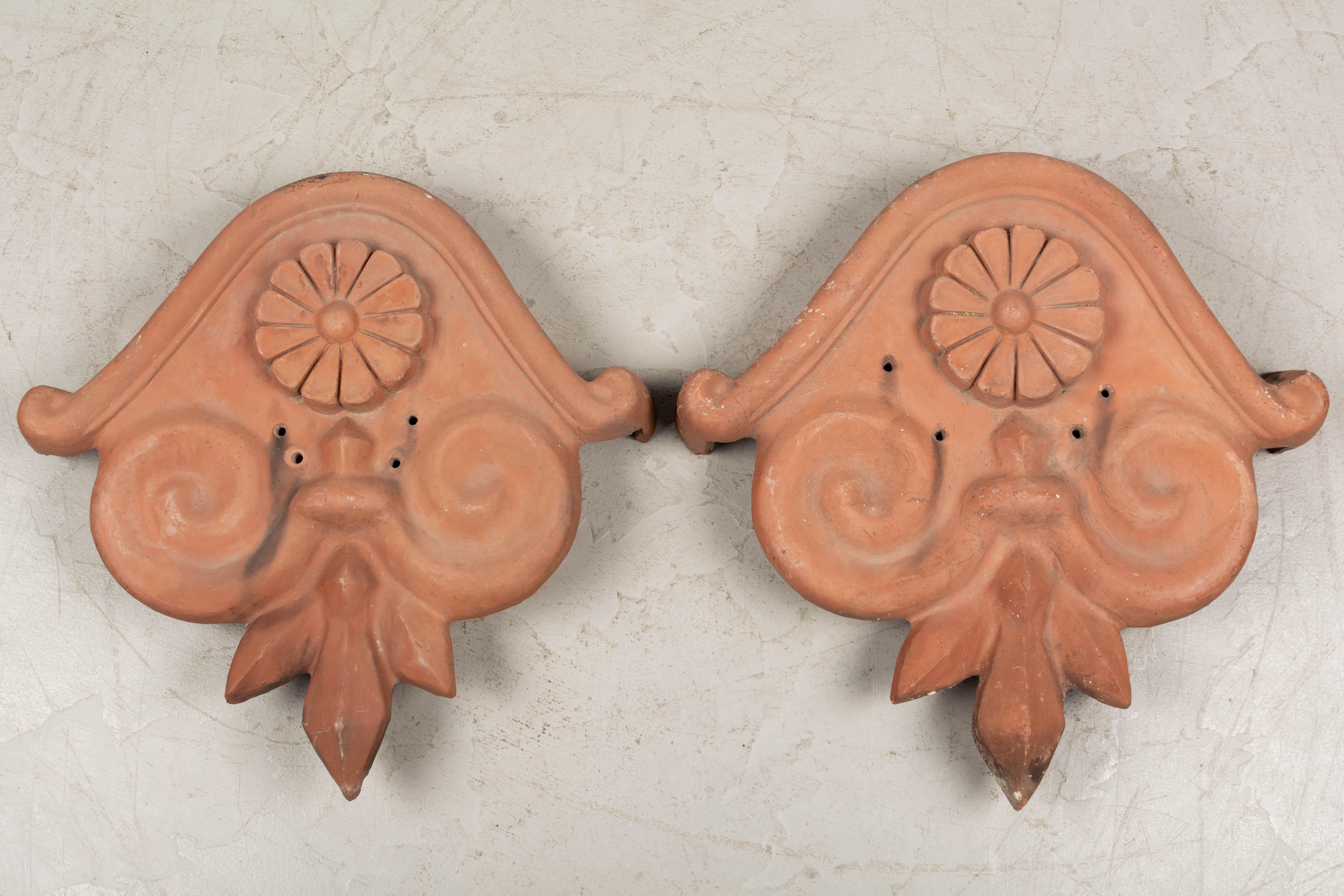 A pair of French terracotta architectural roof decoration. These salvaged architectural ornaments were used to CAP the peak of a traditional sloped terracotta tiled roof. In very good condition. Excellent for use as sculptural elements in the