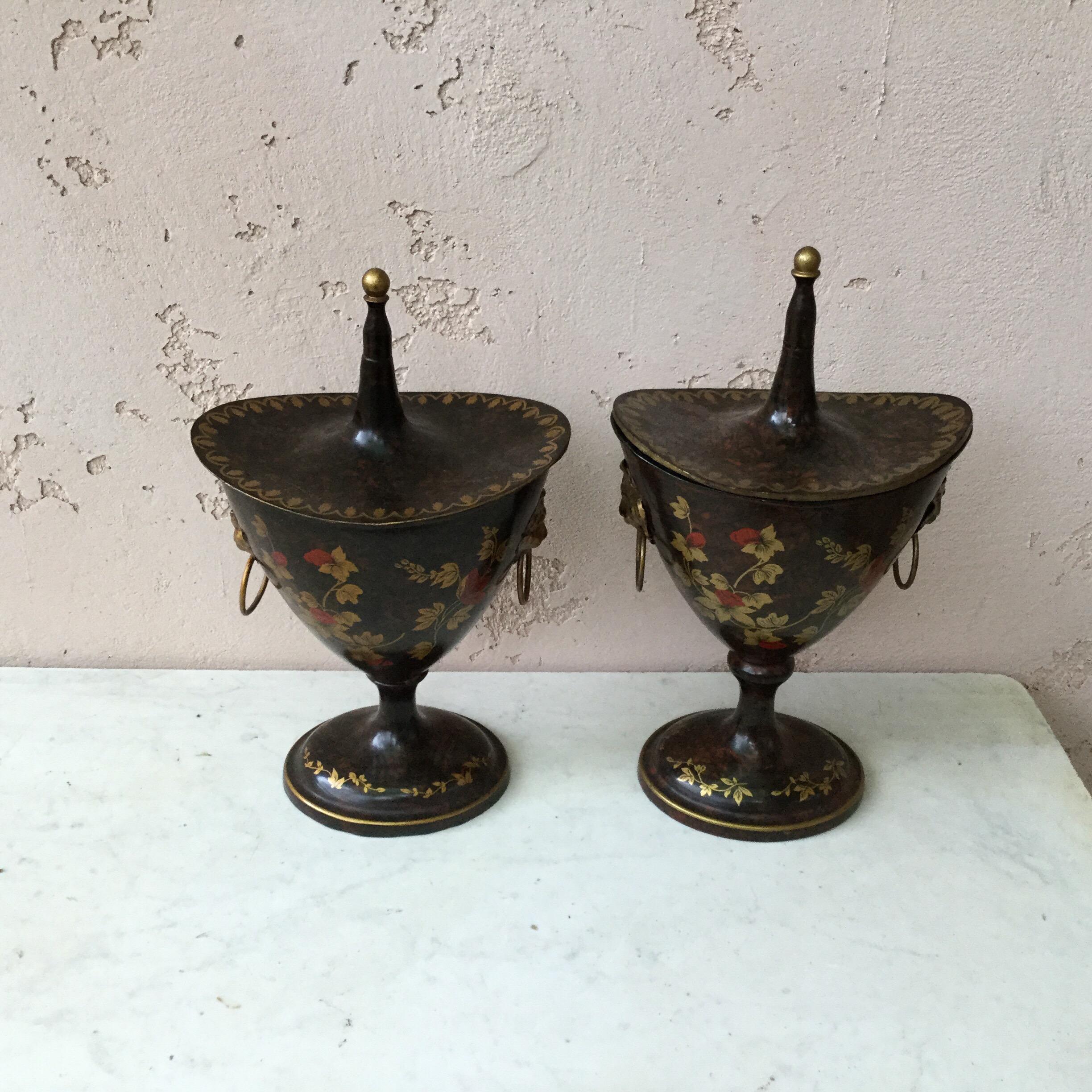 Pair of French painted tole lidded urns with flowers and butterfly painting, handles lion head with ring.