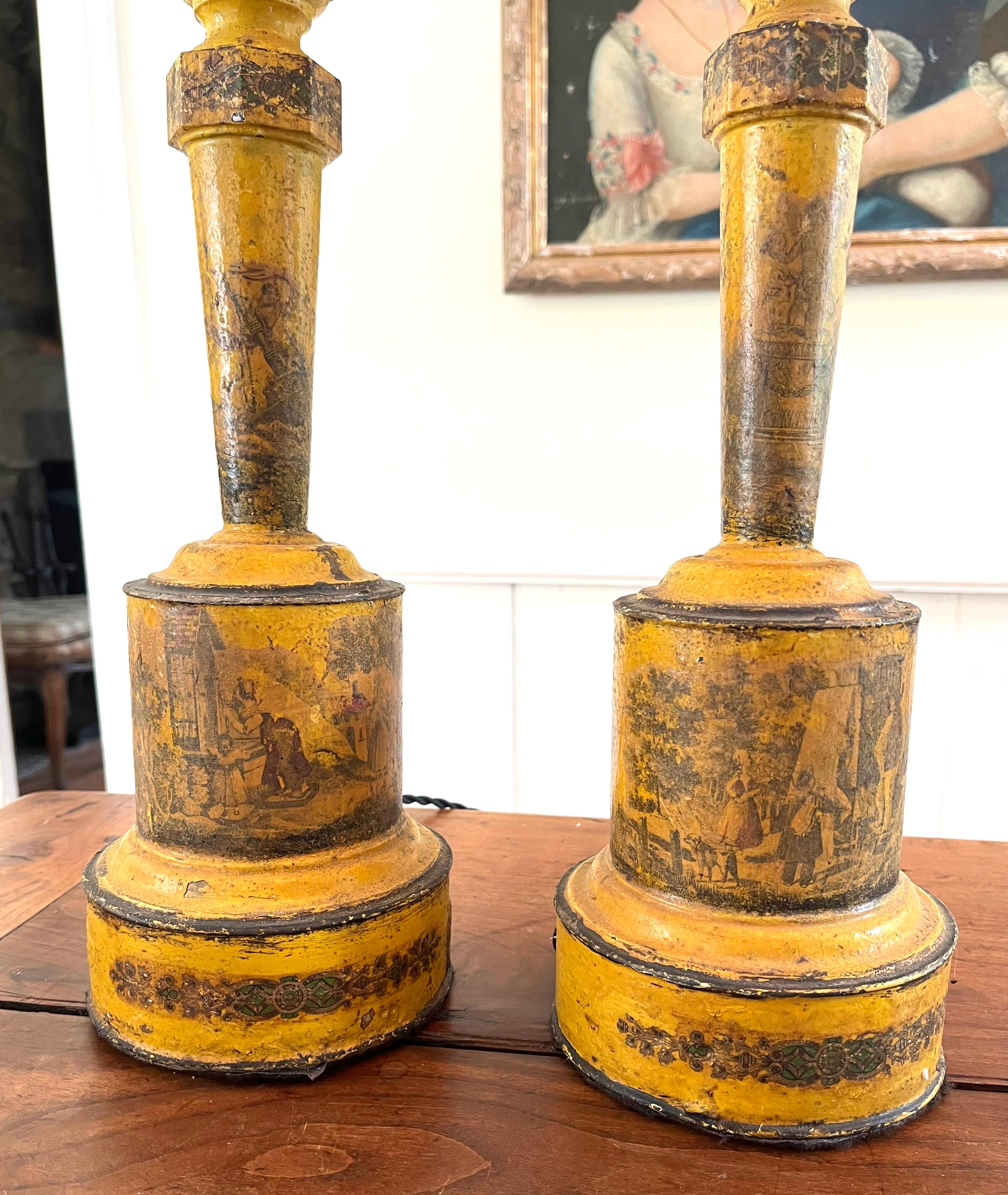 Une paire unique de lampes à huile à tole françaises du XIXe siècle de la fin de la période Empire, décorées en finition peinte jaune avec des scènes lithographiques transférées de la vie à la campagne, électrifiées et recâblées avec un cordon en