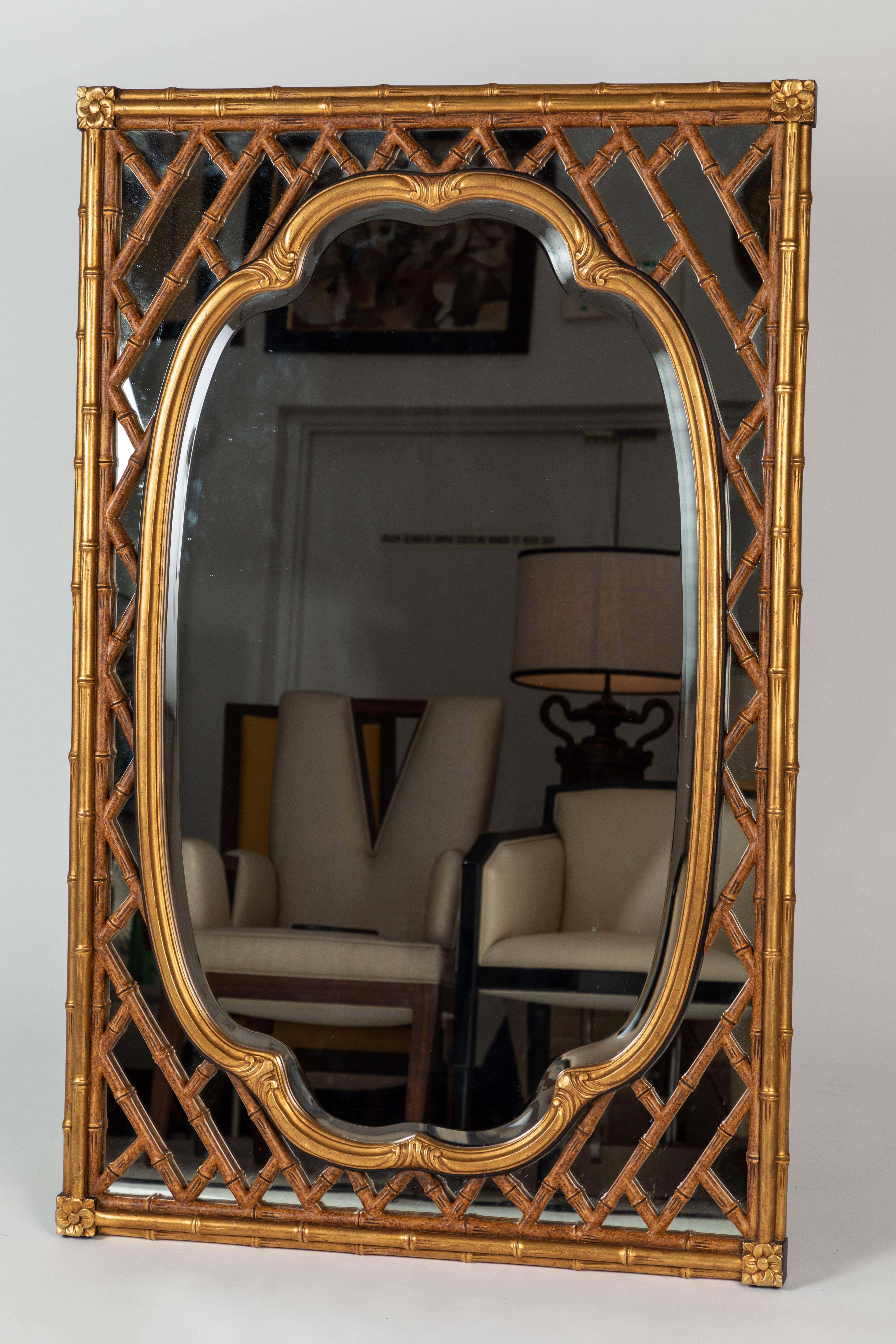 An exquisite pair of bamboo-framed wall mirrors by Mirror Fair for Baker Knapp & Tubbs. 

These rectangular mirrors are framed by a bamboo frame (in manner of a lattice-work design) that highlights the oval-shaped mirror in the centre of the