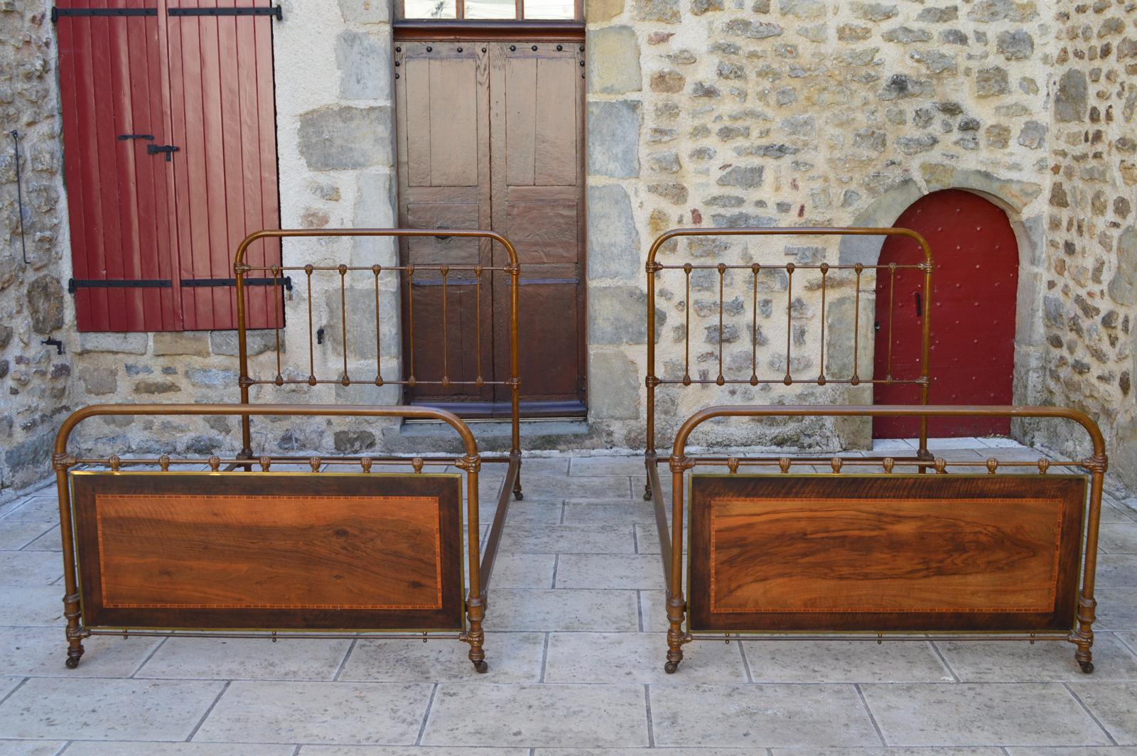 Pair of French twin beds, cast iron fake wood, brass and marquetry, circa 1910.

Superb pair of twin beds.
Made in France, circa 1910.
The structure is in cast iron, painted trompe-l'oeil or faux-bois.
Each bed has an inlaid wood panel